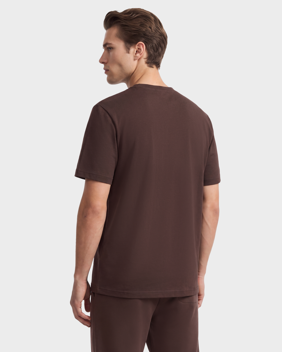 A person viewed from the back wearing a premium cotton crewneck t-shirt and matching shorts in dark brown from the Rudsak GRANT - 6525036 Espresso collection.