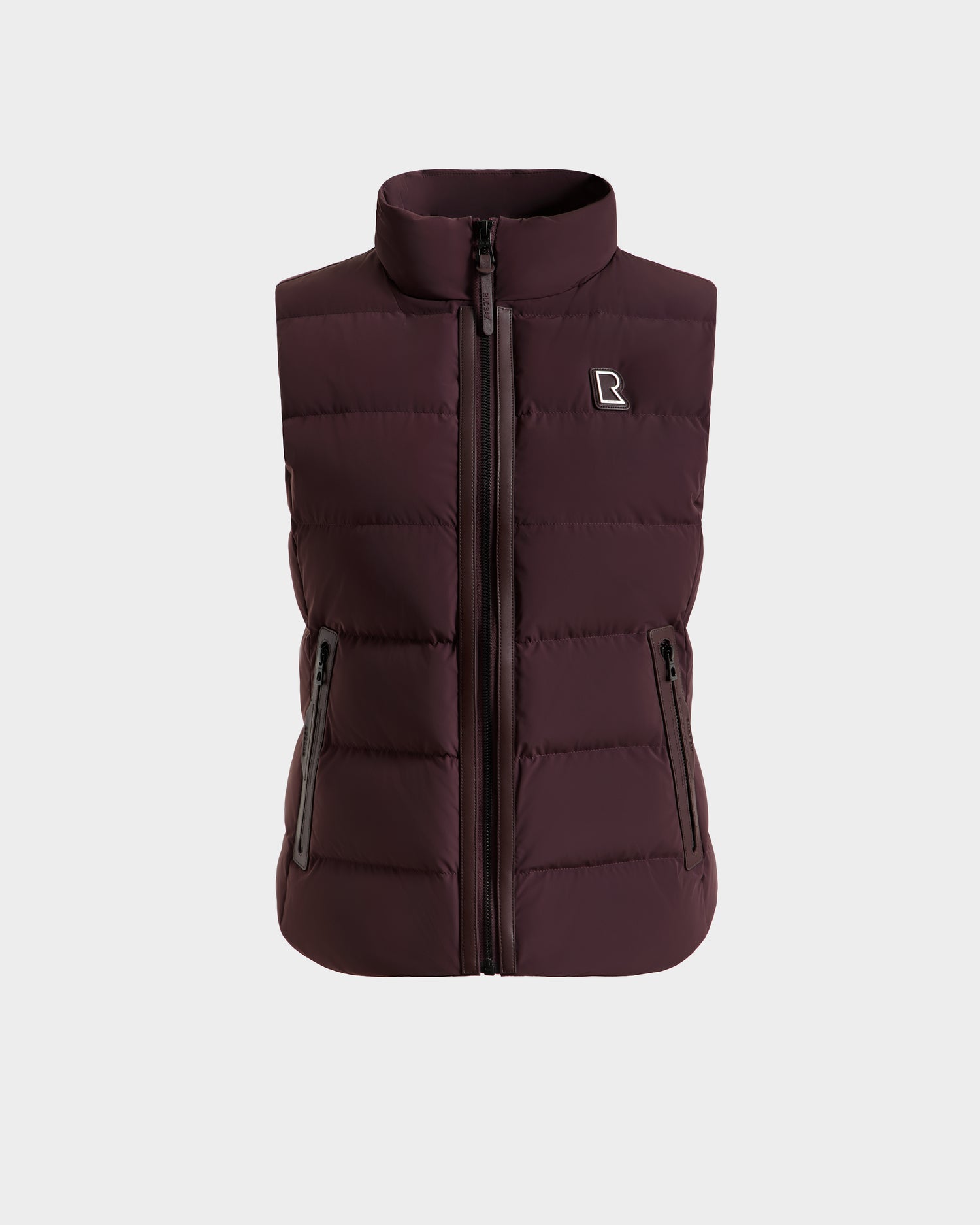 The Rudsak GABRIELA - 8125014 Bordeaux is a maroon, sleeveless lightweight puffer vest with vegan leather trims, front zipper, two zippered side pockets, and a small white logo on the left chest, shown on a plain white background.