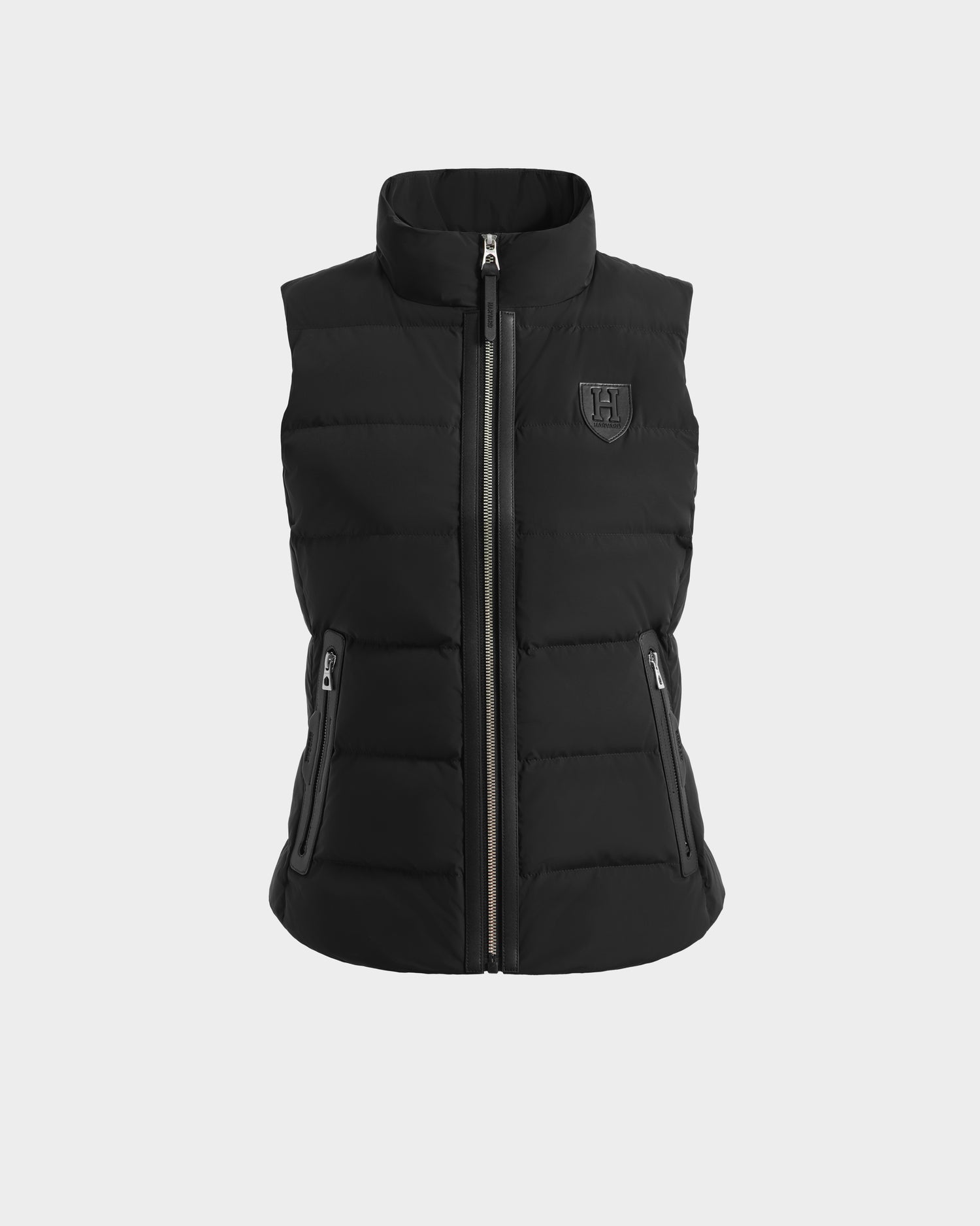 The GABRIELA HV - H125507 Black by Rudsak is a limited-edition black sleeveless quilted puffer vest with a high collar, front zipper, side zip pockets, and a small embossed logo on the left chest, from the Harvard x RUDSAK collection.