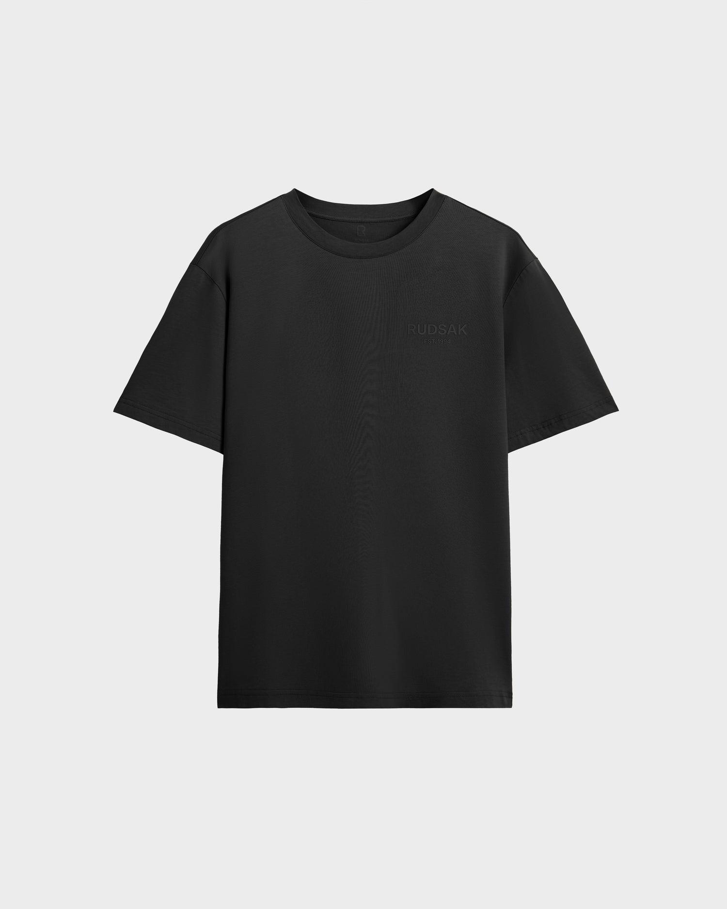 The Rudsak GRANT - 6525036 Black is a men's premium cotton tee with short sleeves and a classic crewneck, shown on a light gray background.
