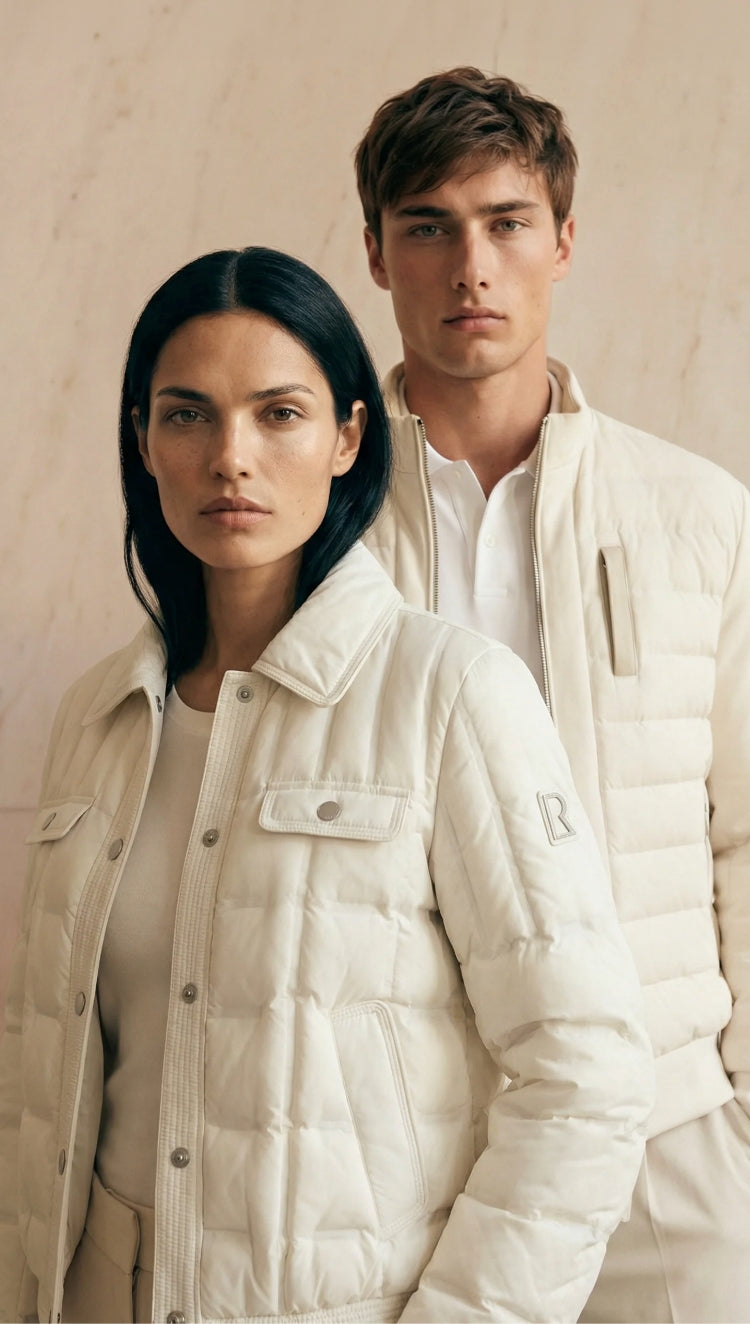 Two people wearing matching white puffer jackets against a neutral background
