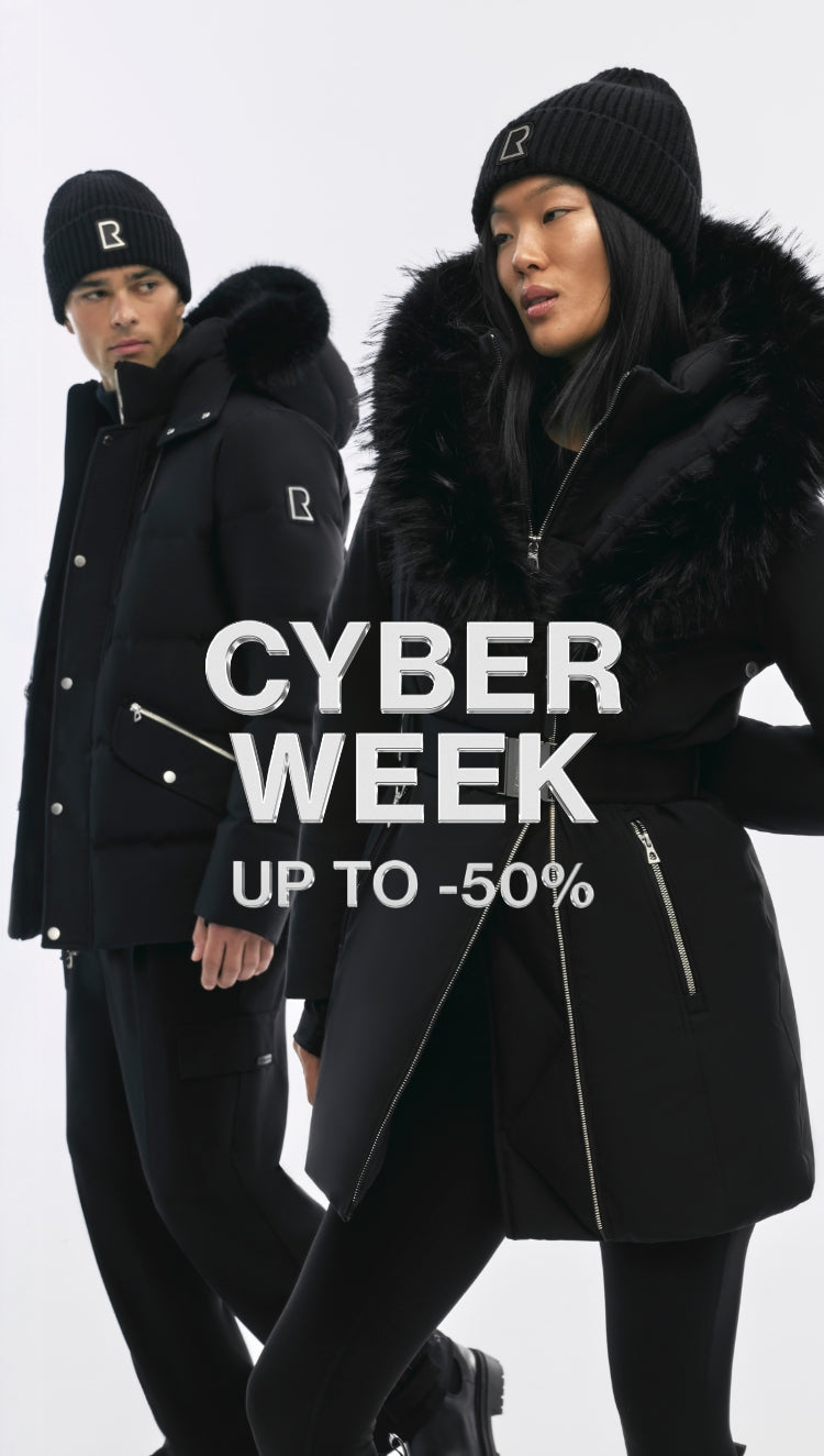 Two people wearing black winter coats and hats with a 'CYBER WEEK' sale text overlay on a white background.