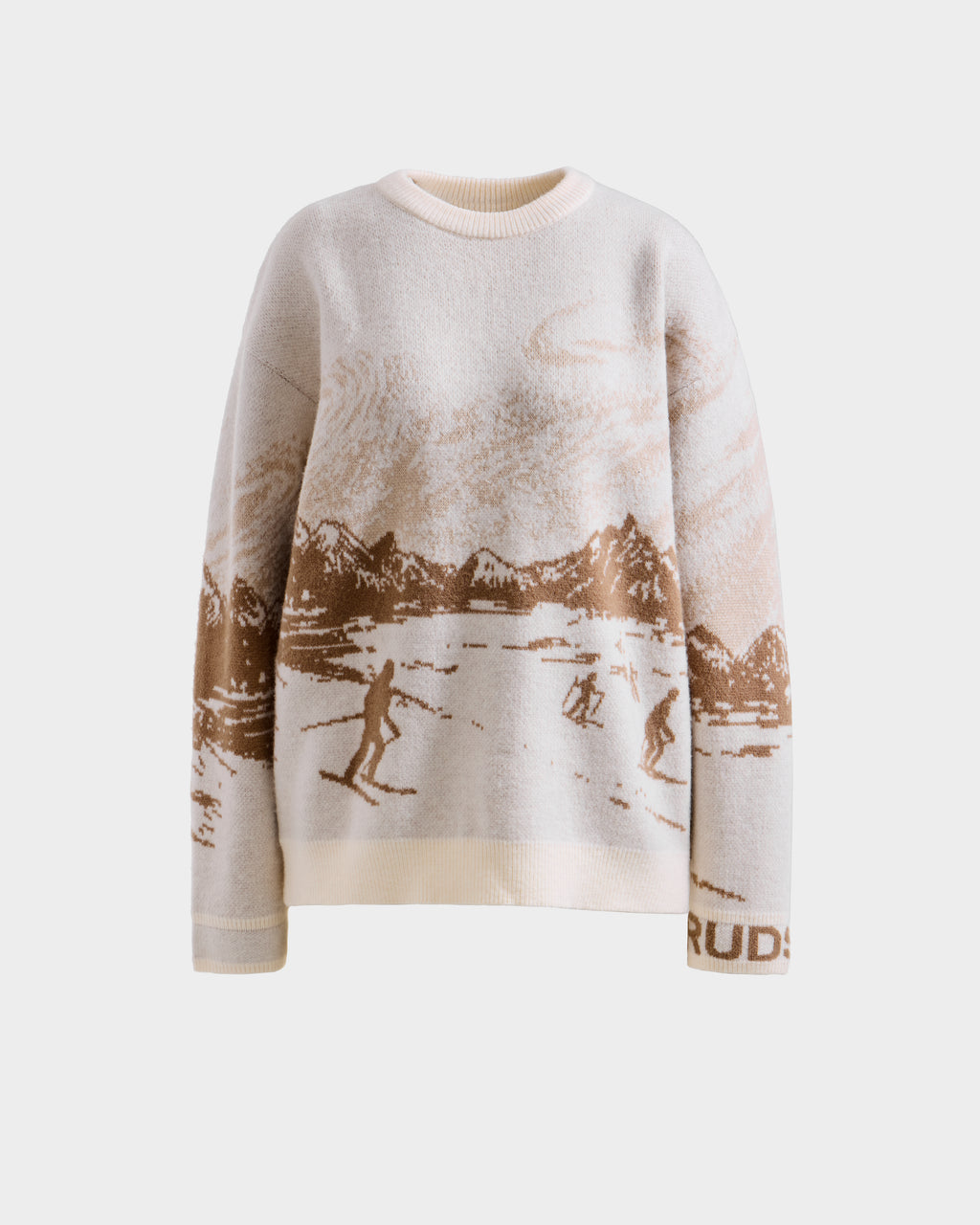 The Rudsak IZZY - 9525557 Iceland W is a cream unisex knit sweater with a brown alpine skiing scene, mountain and cloud pattern, and "RUD" on the sleeve—ideal for après-ski style.