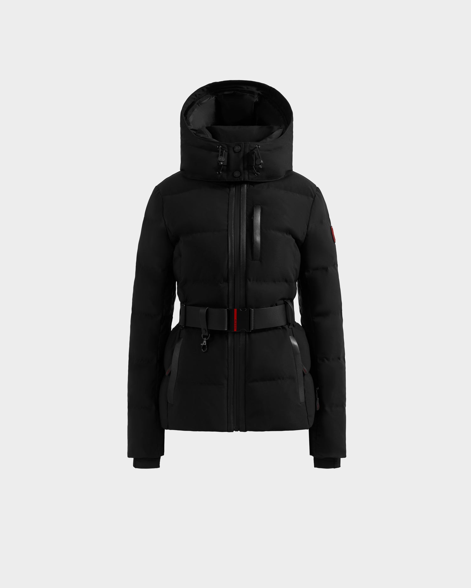 The JOANNA - 8124788 Black by Rudsak is a black, padded winter jacket with hood, front zipper, chest pocket, belted waist, long sleeves, fitted design, and red sleeve accent. Pre-order now; ships by November 30th.
