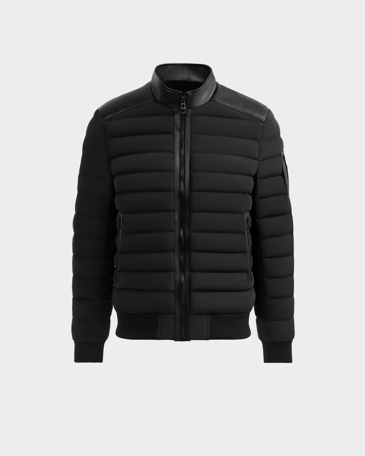 The Rudsak JOSHUA - 6125722 Black is a black, quilted down jacket featuring a front zipper, high collar, and ribbed cuffs and hem, shown against a plain white background.