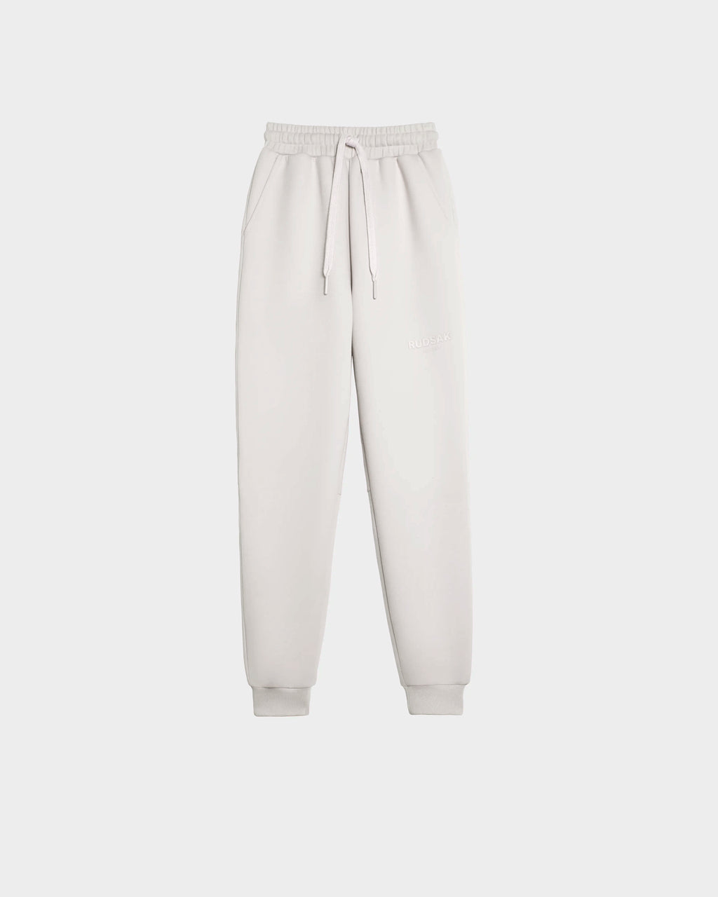 The JOSS - 9524009 Vanilla M joggers by Rudsak feature light grey premium cotton, elastic waistband, drawstring, cuffed ankles, relaxed fit, and subtle embroidered text on the left thigh, shown on a plain white background.