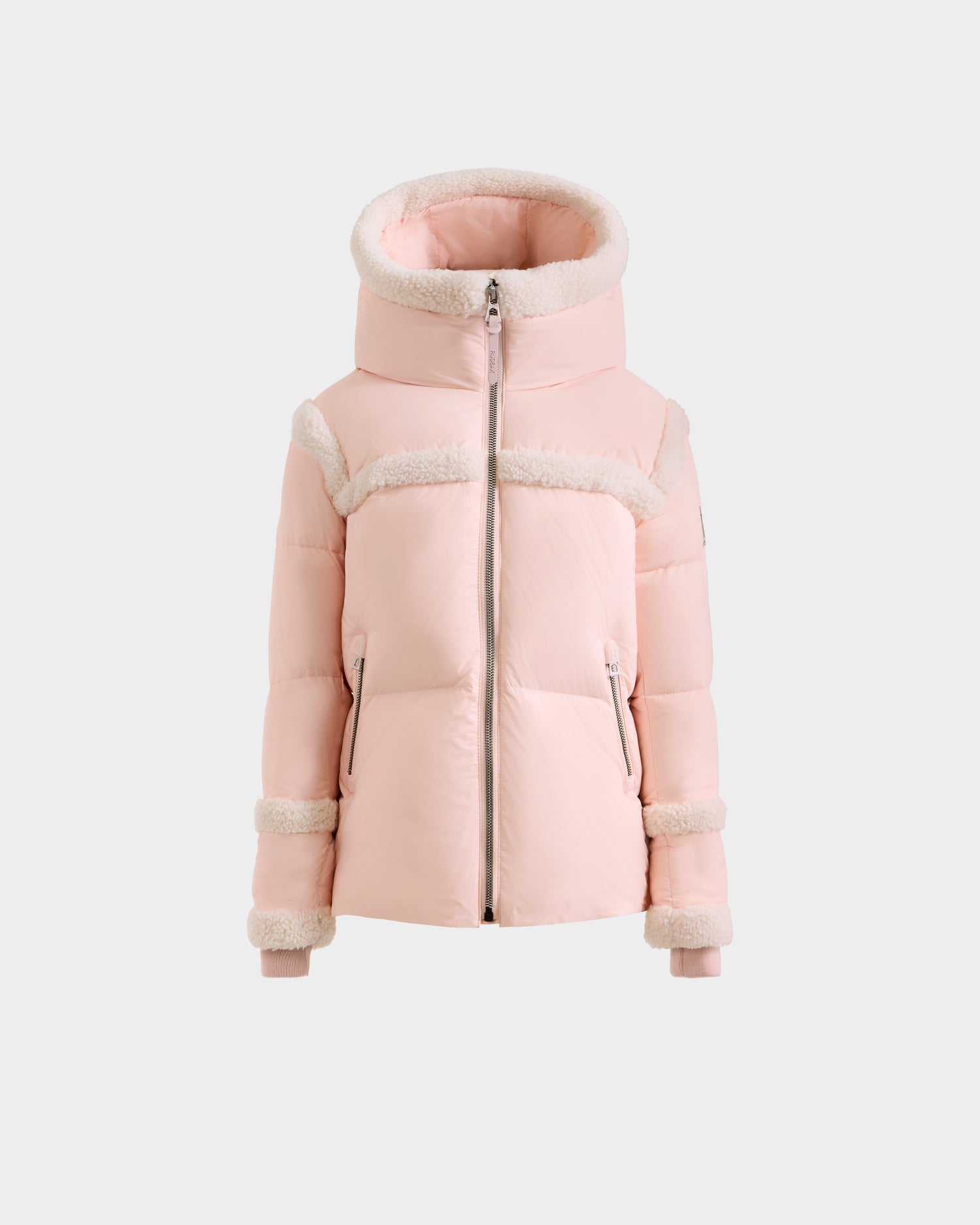The JULIANA K - K125550 Pastel Pink puffer jacket by Rudsak features a large hood, white faux fur trim on the hood, cuffs and sleeves, and two front zippered pockets, all shown against a plain gray background.