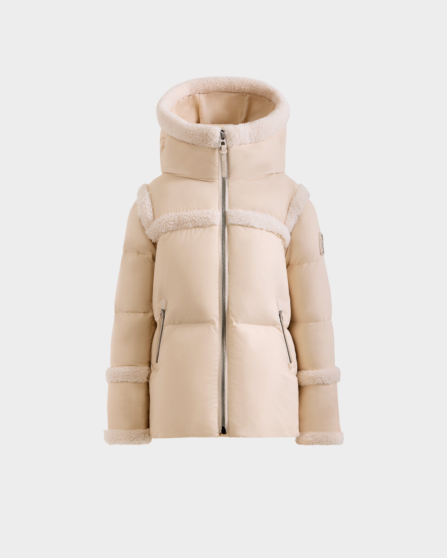The Rudsak JULIANA K - K125550 Vanilla is a beige hooded puffer jacket with plush fleece trim on the sleeves, hood, and chest. It features a front zipper closure and side pockets, shown against a plain white background.