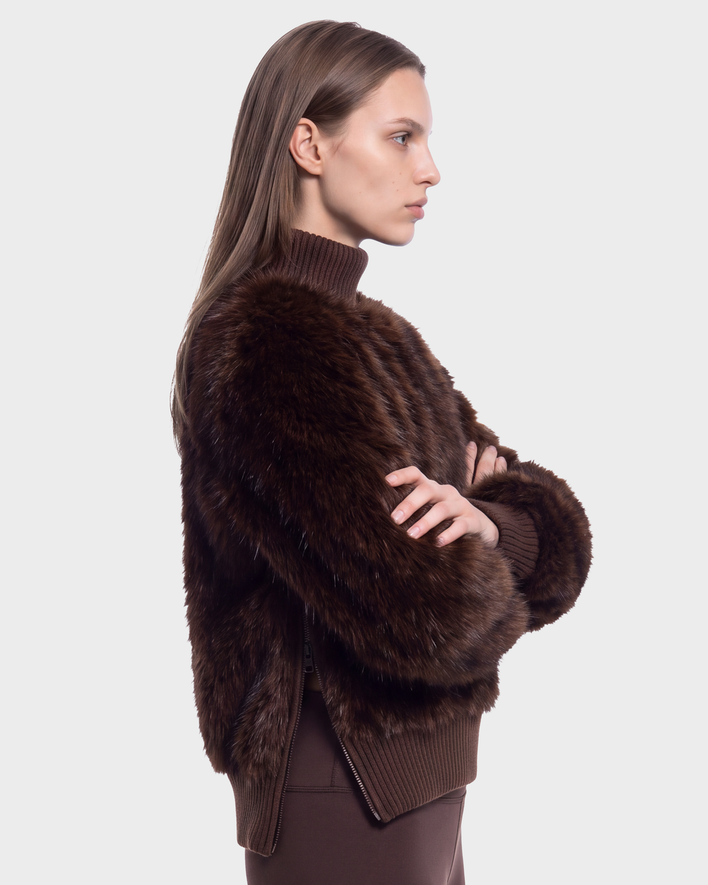 A person viewed from the side with arms crossed, wearing a dark brown faux fur turtleneck Rudsak LAYLA F - 8525630 Mix Expresso sweater with a cable textured design and ribbed trim.