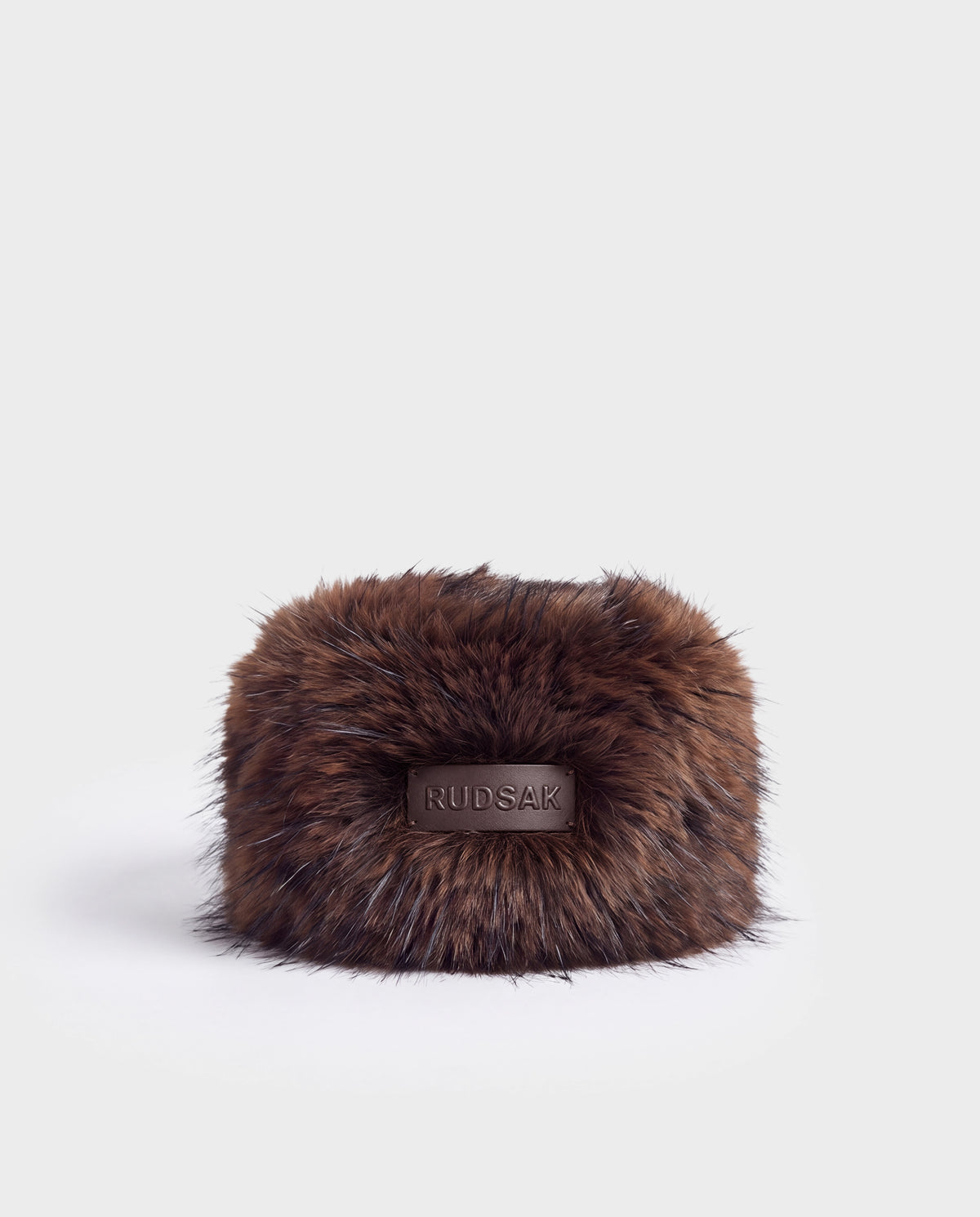 LORETTA - 8426503 Mix Espresso brown faux-fur headband with a leather logo patch on the front.