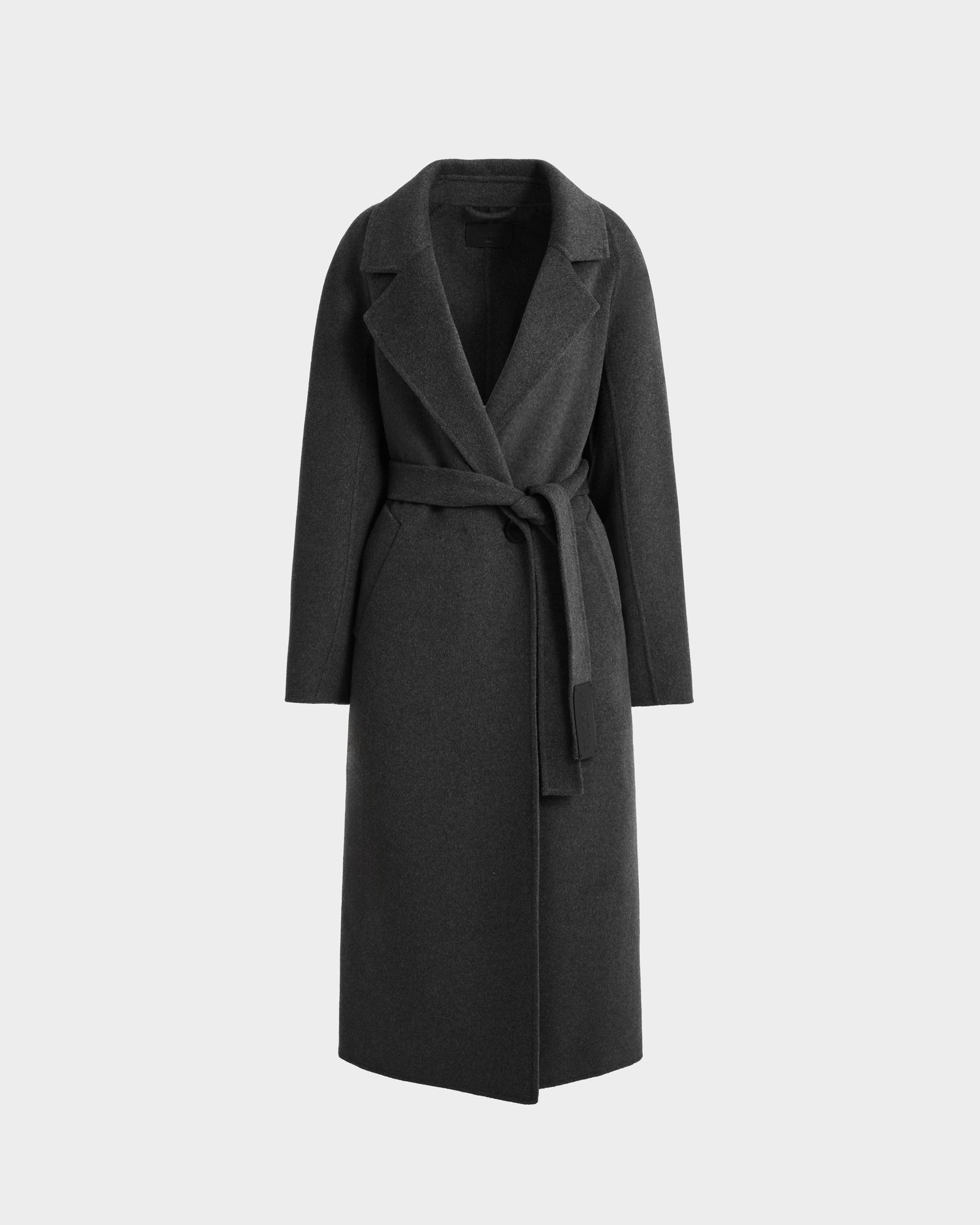 The Rudsak LILIA - 8125634 Heather Charcoal women’s long wrap coat features dark gray wool, a wide collar, and a matching fabric belt for timeless elegance, shown against a light gray background.