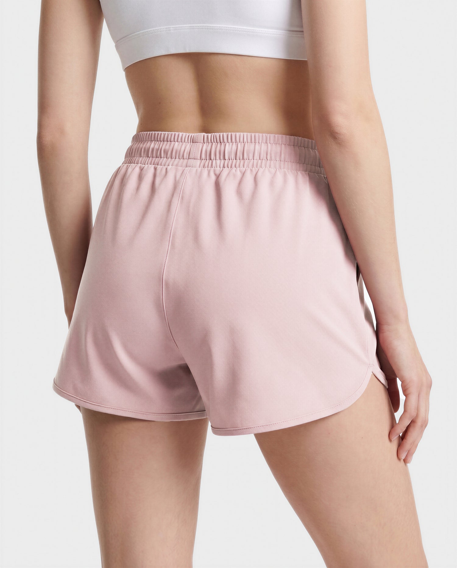 A person is seen from the back against a plain background, wearing a white crop top paired with Rudsak's SAMMY - L523014B Bottom in Soft Pink.