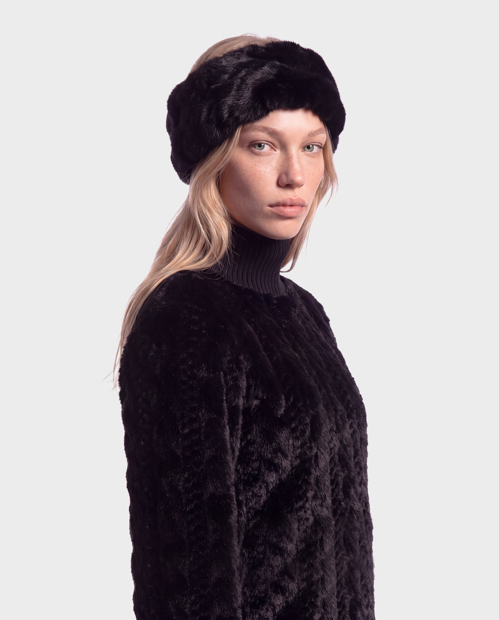 A person wearing a black faux-fur headband and a matching black MILA - 8426518 Black sweater by Rudsak.