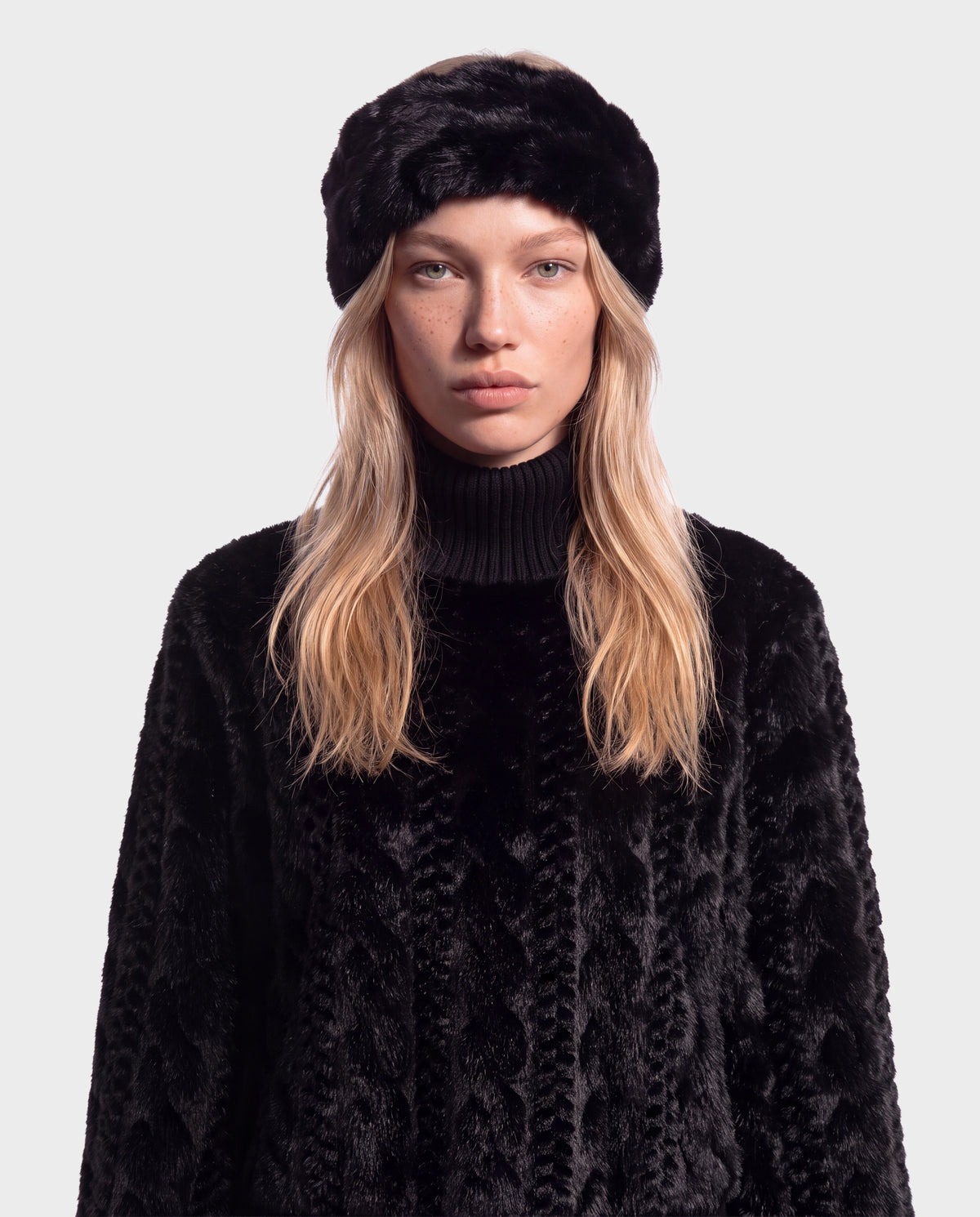 A person wearing a MILA - 8426518 Black faux fur headband and a matching textured black sweater.