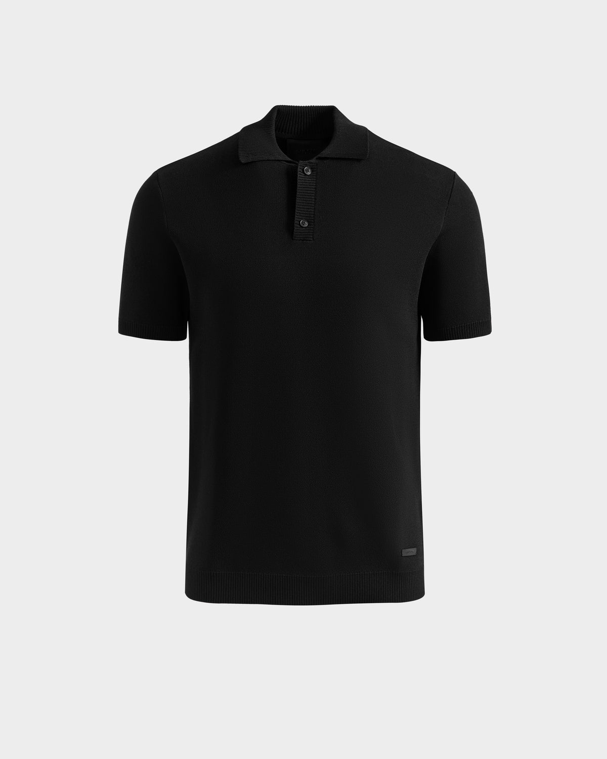 The Rudsak MAISEN - 6524518 Black is a men’s short-sleeve knit polo featuring a ribbed collar, three-button placket, and minimal design—an essential wardrobe piece, shown against a plain light gray background.