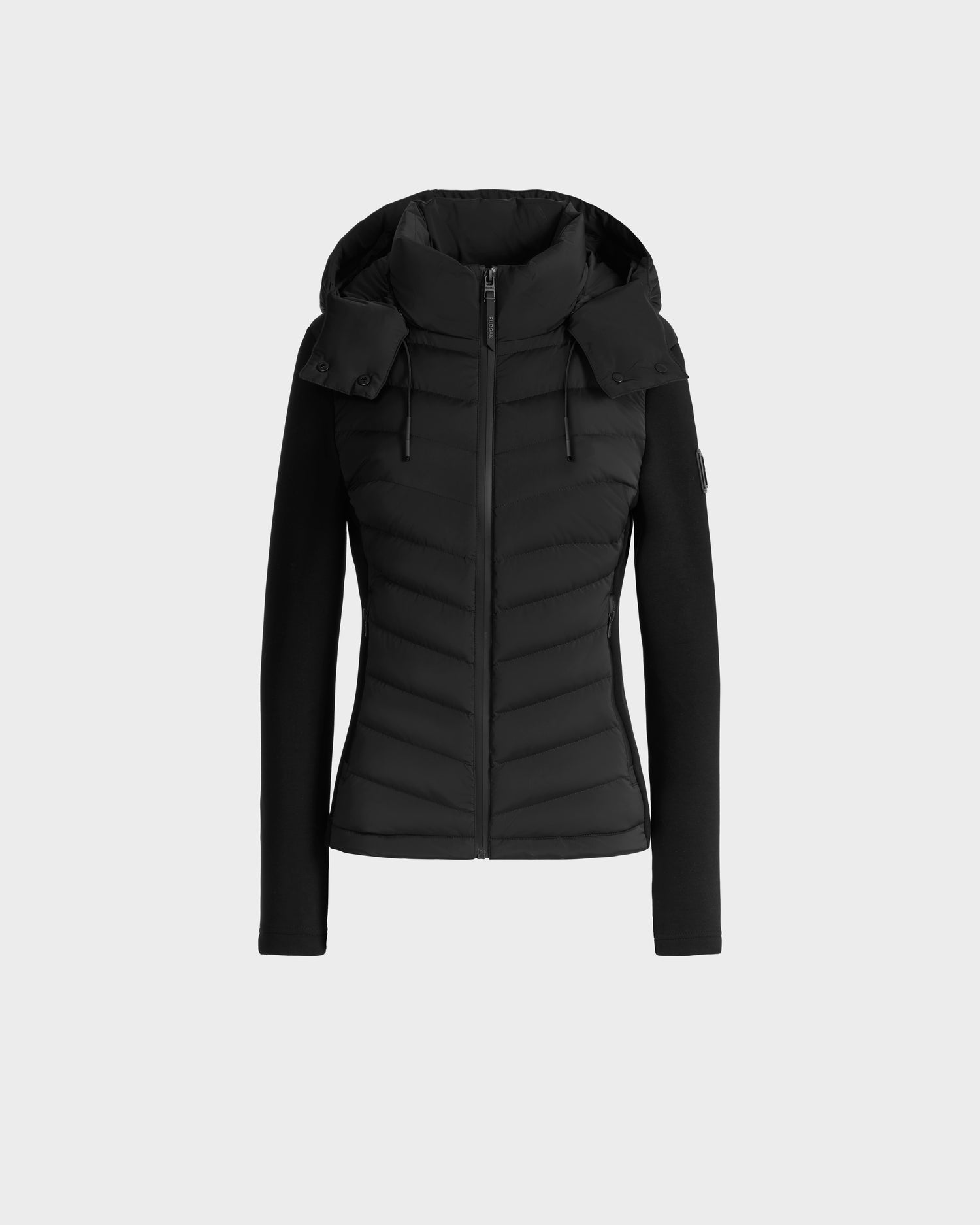 The Rudsak MALYA M - L125036 Black is a fitted zip-up jacket with a hood and down-quilted front and sleeves, shown against a plain light gray background.