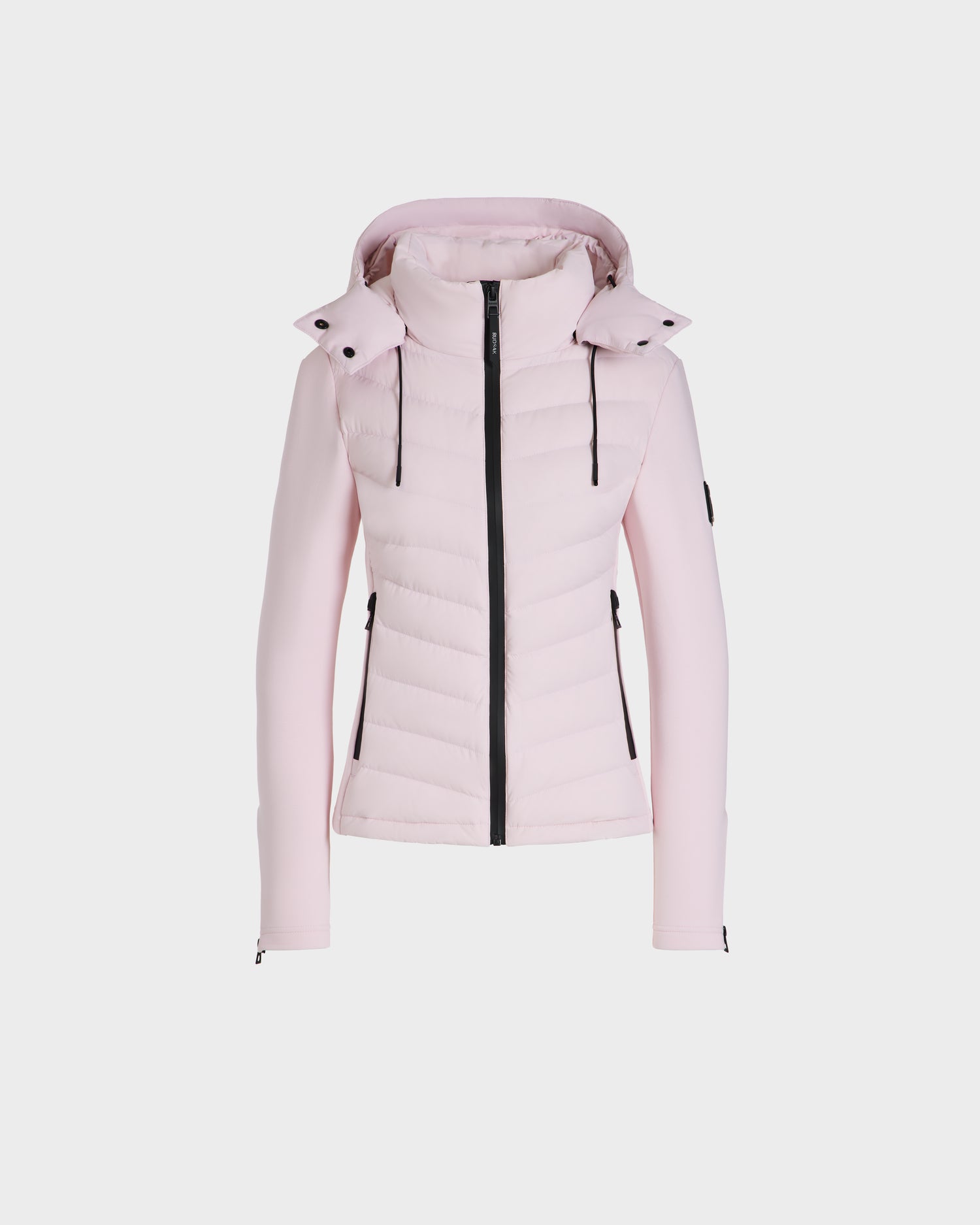 The Rudsak MALYA M - L125036 Light Pink is a fitted women's activewear jacket with a hood, black front zipper, black drawstrings, and zippered side pockets, shown on a plain white background.