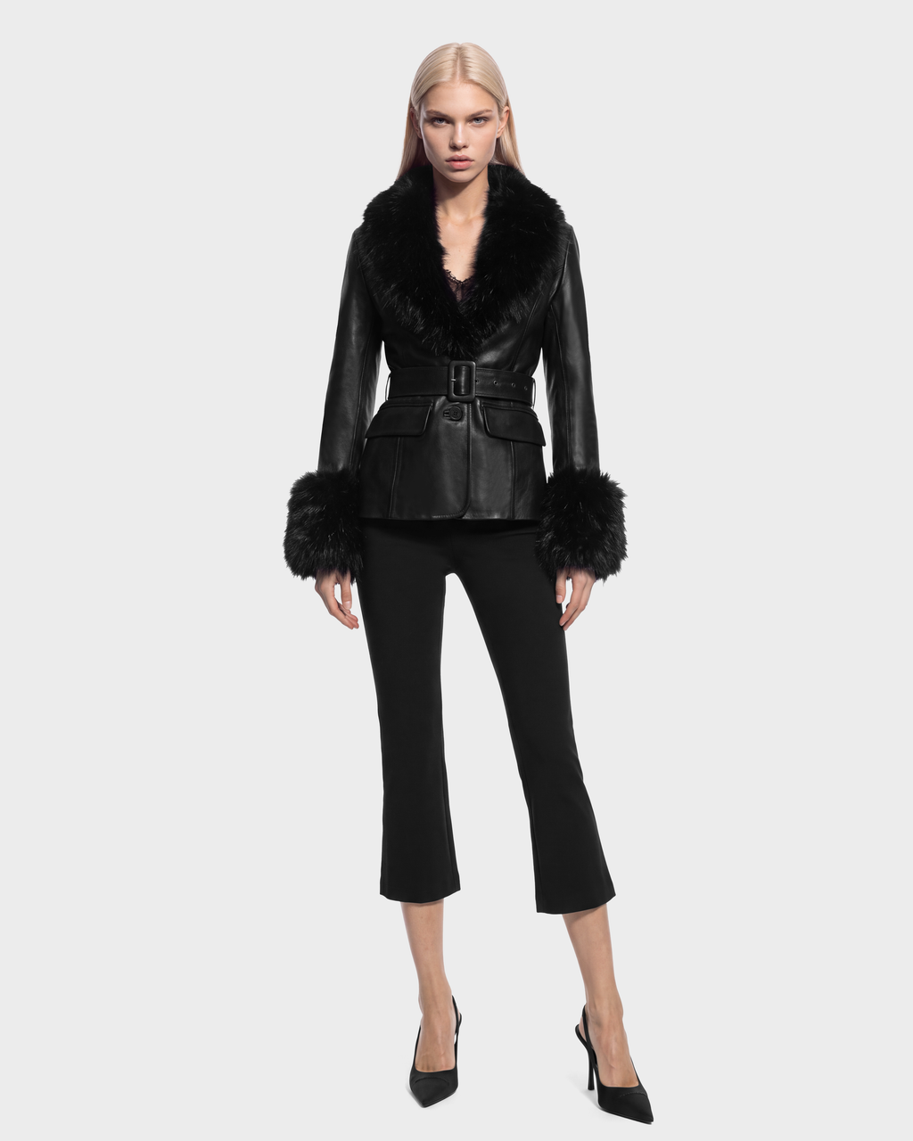 Model wearing a MARILLA - 8126972 Black leather jacket with a faux fur collar and cuffs, a belted waist, and cropped black trousers with black pumps.