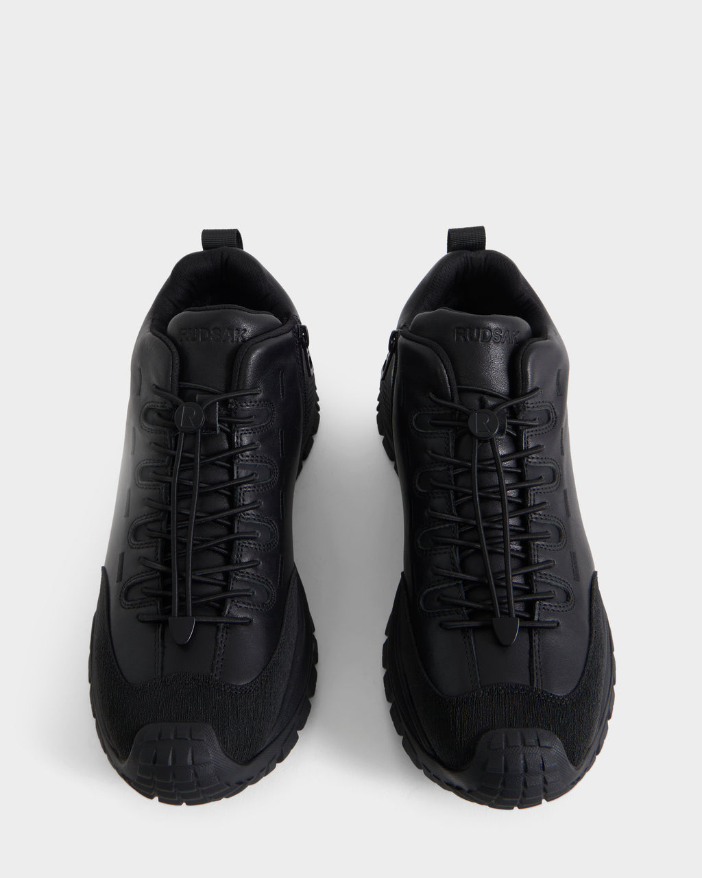 A pair of Rudsak MAX - 6226502 Black men’s sneakers, showcasing utility-inspired detailing and an athletic lace-up design, are viewed from above on a white background.