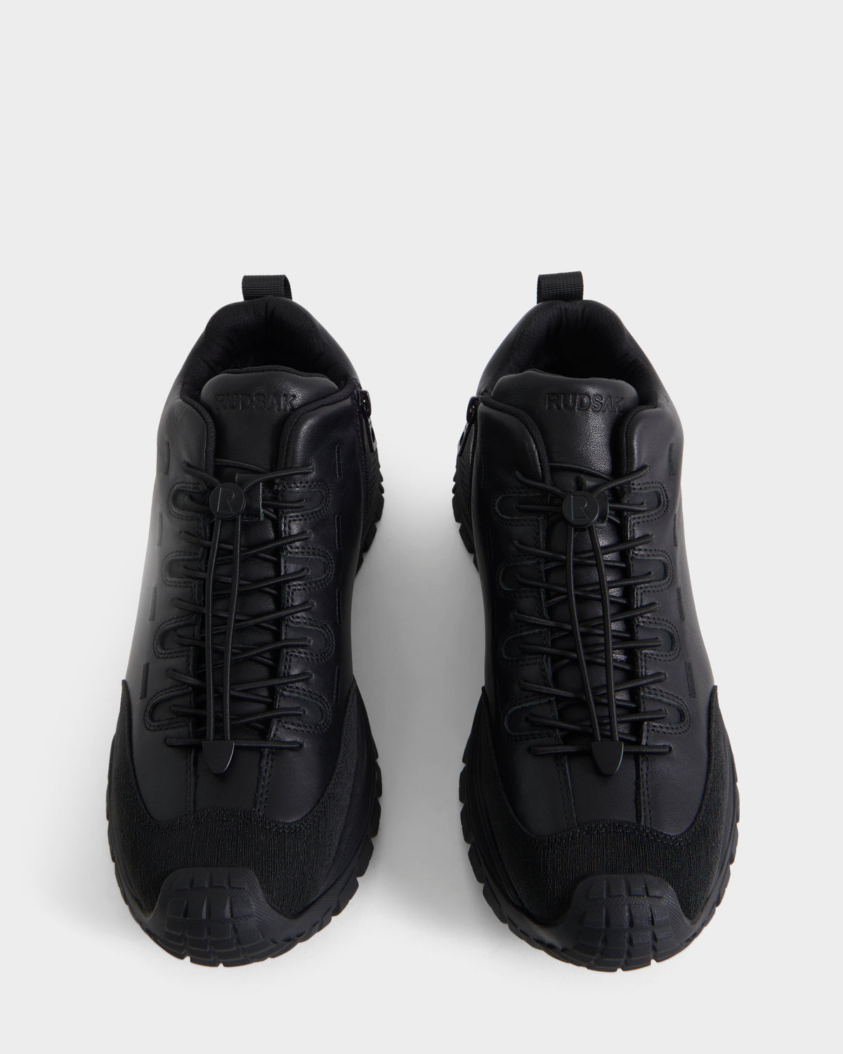 A pair of Rudsak MAX - 6226502 Black men’s sneakers, showcasing utility-inspired detailing and an athletic lace-up design, are viewed from above on a white background.