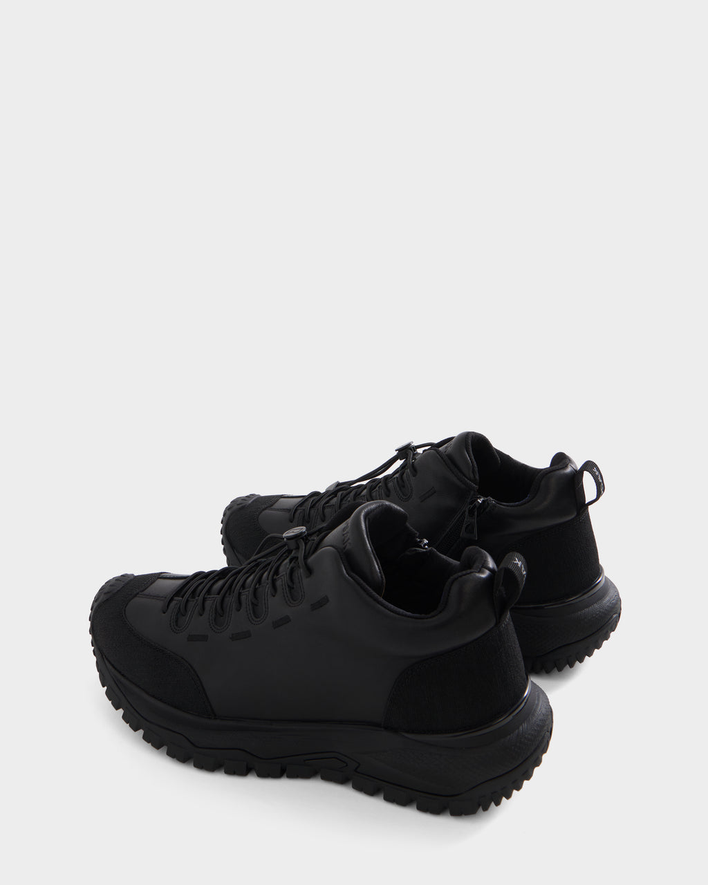 A pair of Rudsak MAX - 6226502 Black men’s sneakers featuring a modern lace-up design, thick textured soles, and utility-inspired detailing, shown from a rear side angle against a plain white background.
