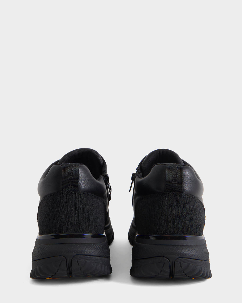 A pair of Rudsak MAX - 6226502 Black men’s sneakers viewed from the back, featuring utility-inspired detailing on the heel and a textured sole against a plain white background.