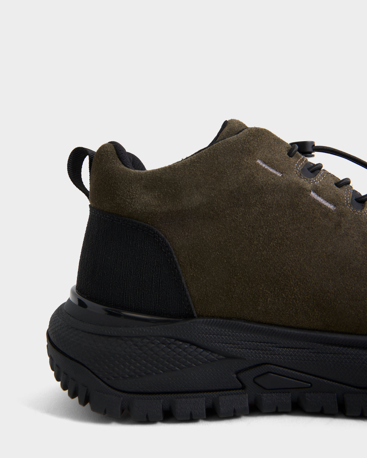 Close-up of the back half of the Rudsak MAX S - 6226505 Olive men’s sneaker, featuring dark green suede, a thick black textured sole, and a trail-inspired heel loop.
