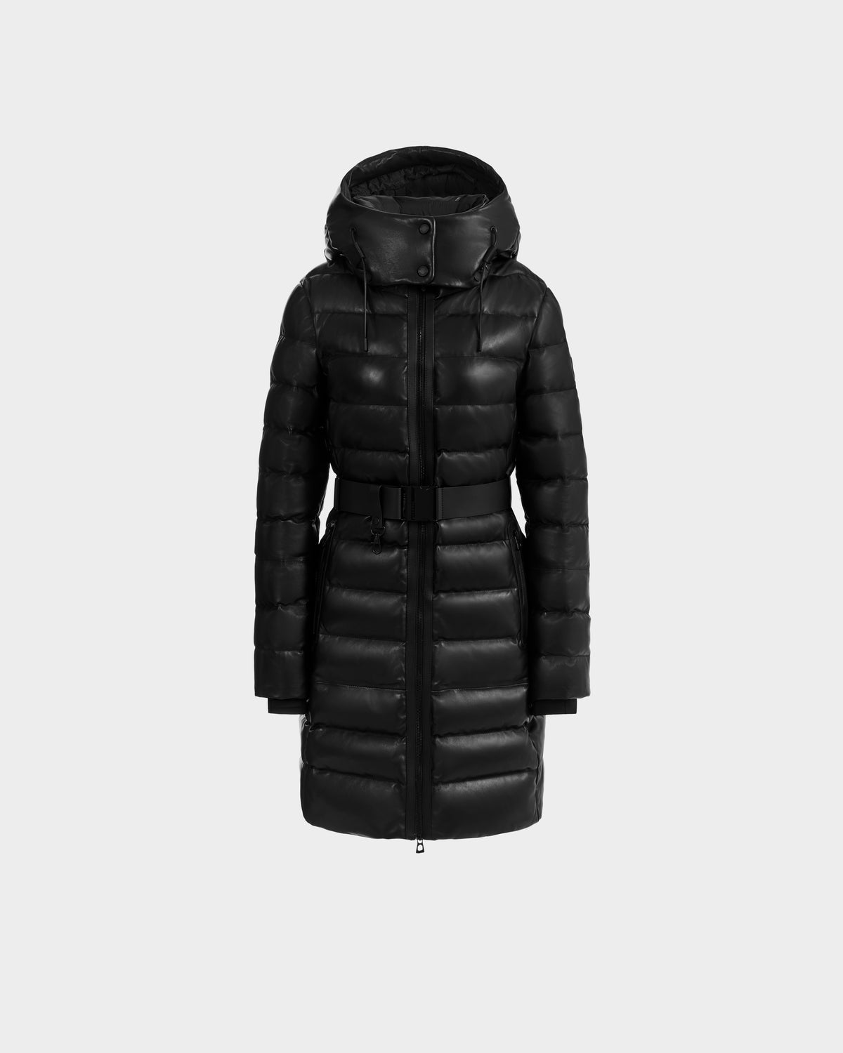 The Rudsak PELIN X - 8125575 Black is a long women's puffer coat with a hood, front zipper, buttons, and a belted waist, shown on a plain light gray background. This coat offers comfort and elegance for winter days.