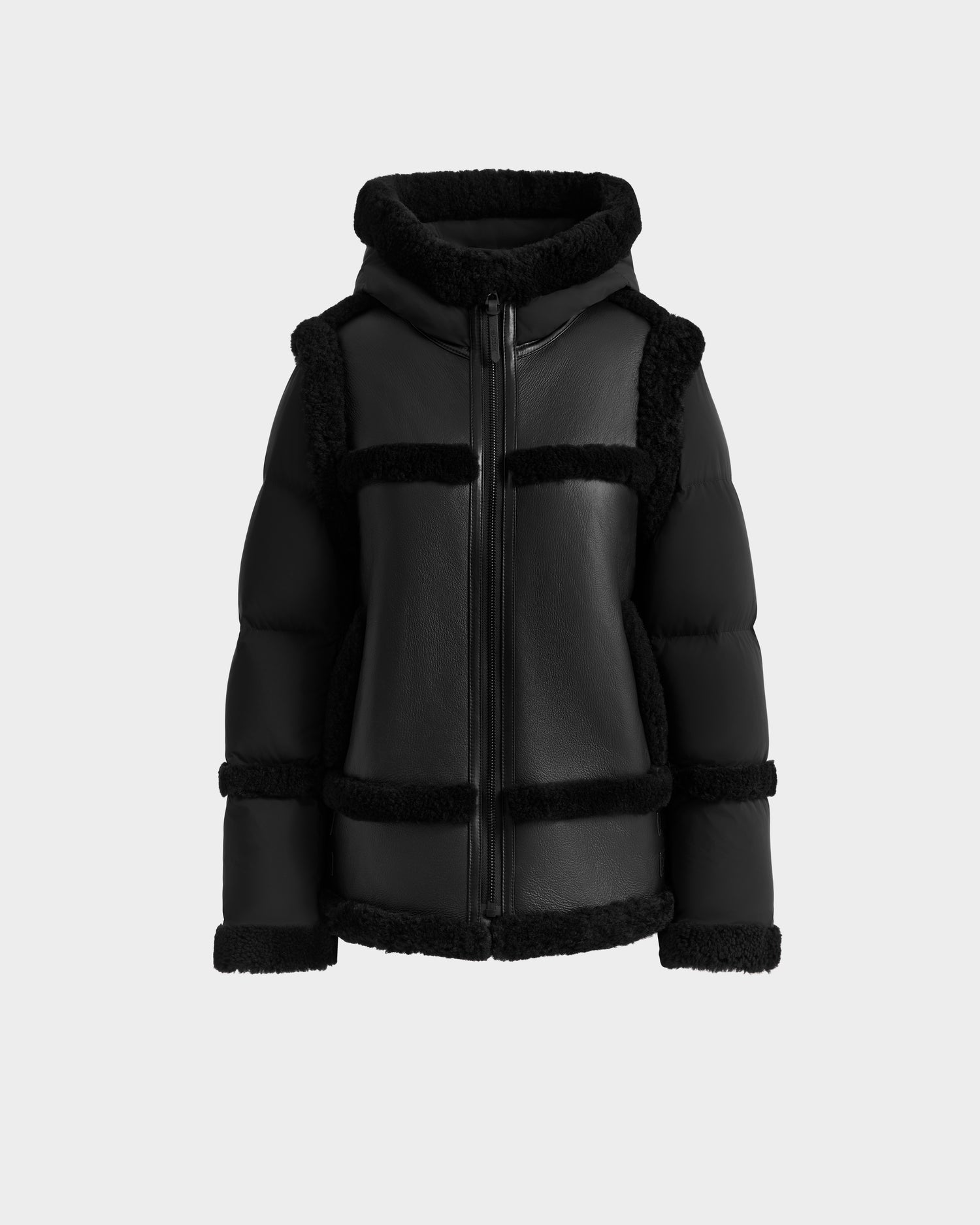 The PHEOBE - 8125510 Black by Rudsak blends modern style with classic shearling in a black puffer jacket, featuring a front zipper, hood, and textured trim—perfect transitional outerwear on a light gray backdrop.