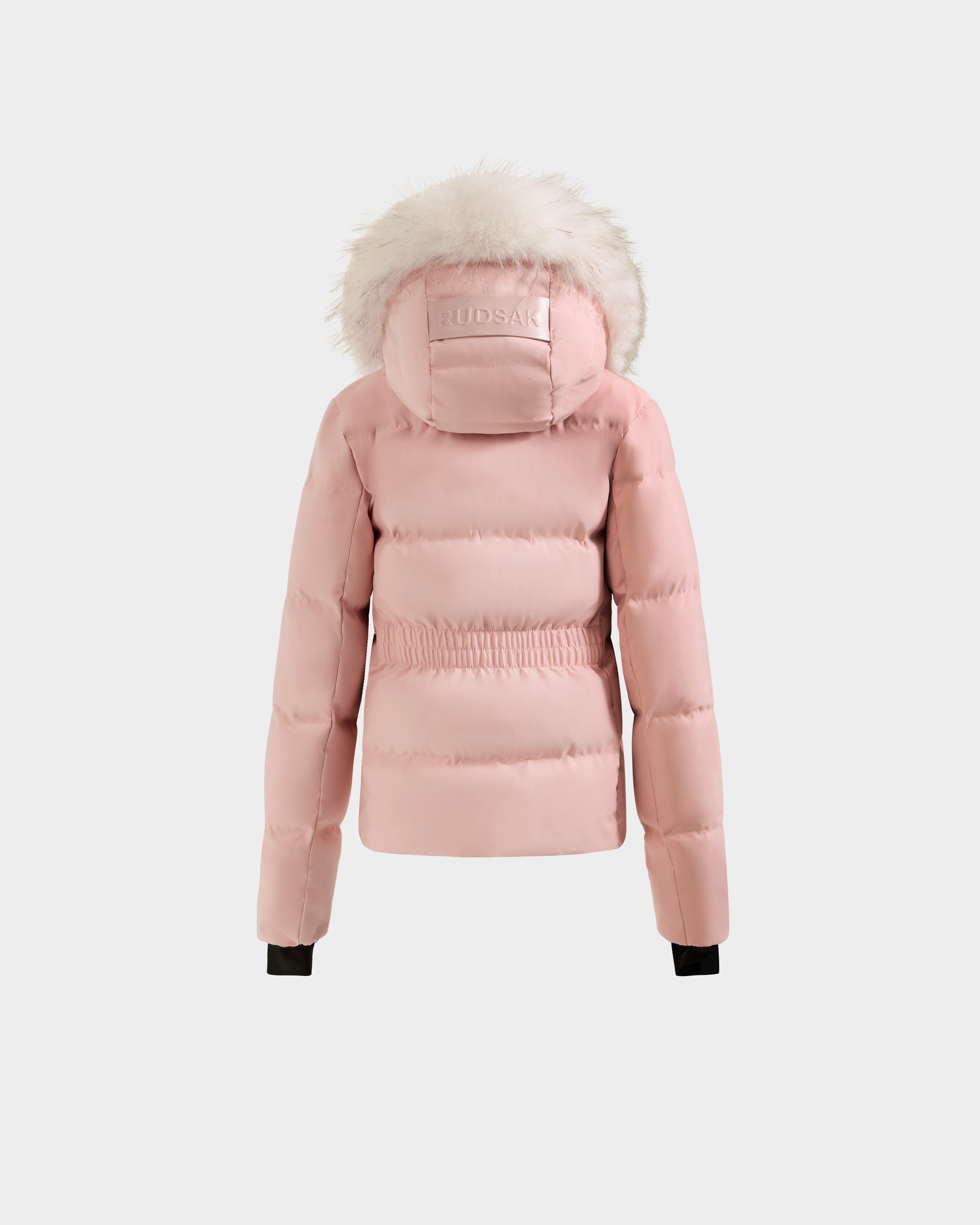 The Rudsak RAEGAN - 0125503 Pastel Pink is a light pink puffer jacket with a fur-trimmed hood, elastic waistband, black cuffs, and Rudsak branding on the hood, shown on a plain white background.