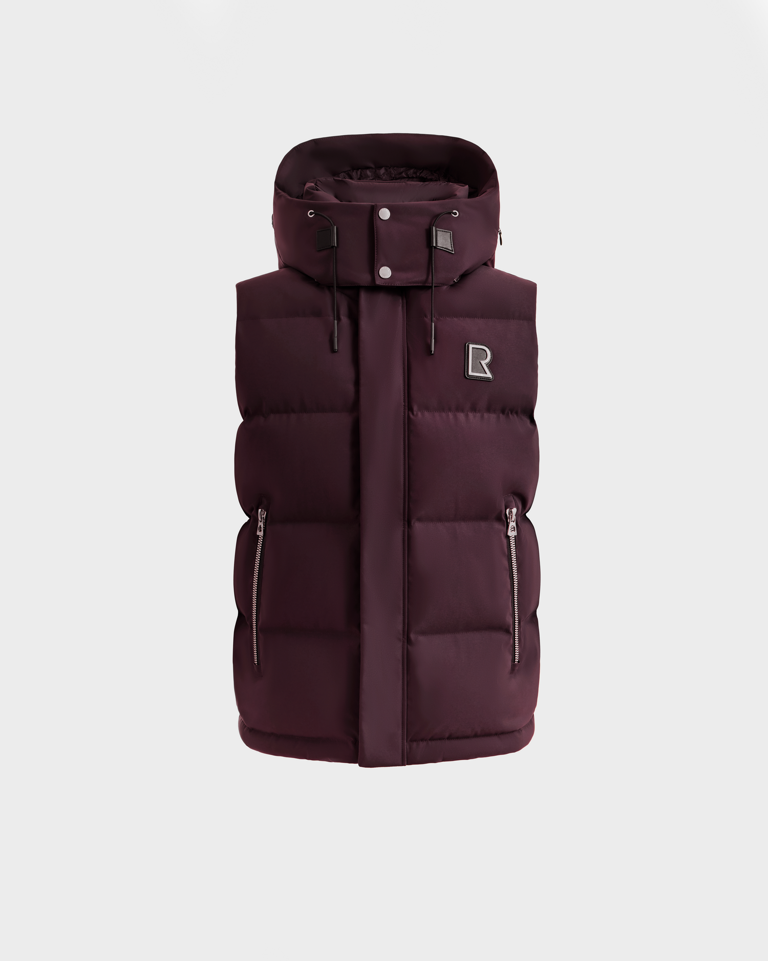 The Rudsak REN H - 6125688 Bordeaux is a men’s sleeveless dark burgundy puffer vest featuring a high collar, detachable hood, two zippered side pockets, and an 'R' patch on the chest—shown against a plain white background.