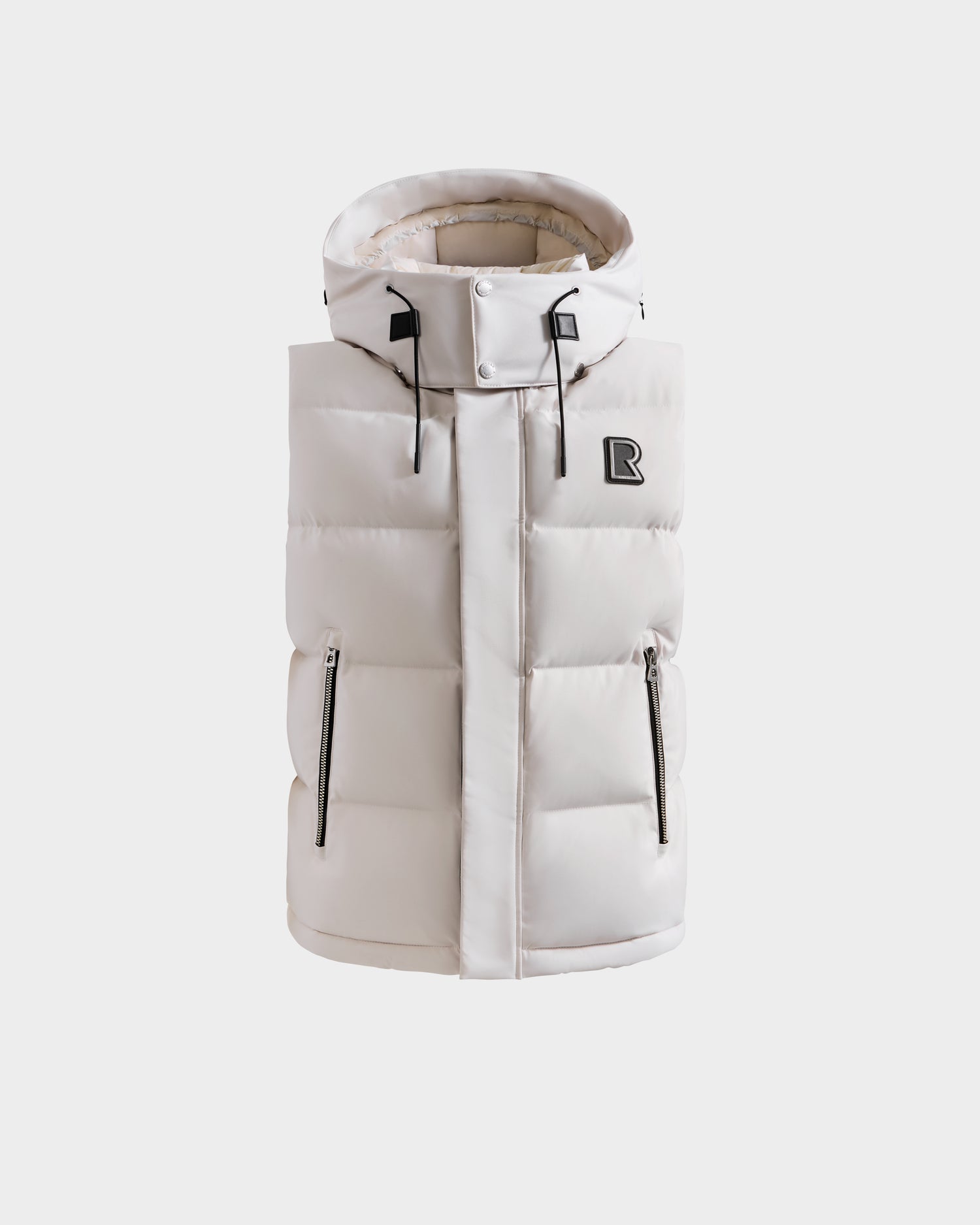 The REN H - 6125688 Vanilla by Rudsak is a sleeveless, off-white quilted down vest with a high collar, removable hood, two zippered side pockets, and a black R logo patch on the left chest, shown on a plain white background.