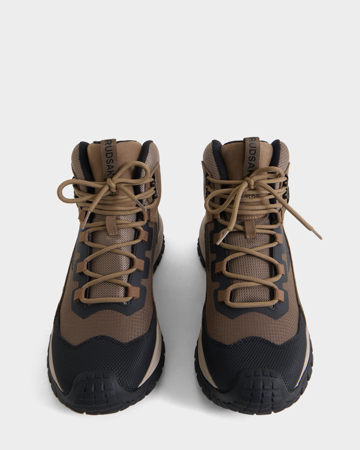 A pair of Rudsak REXON - 6226503 Cement hiking boots in brown and black with tan laces are placed side by side on a white background, displayed from a front, slightly overhead angle, blending the classic look of a winter boot with the comfort of a high-top sneaker.