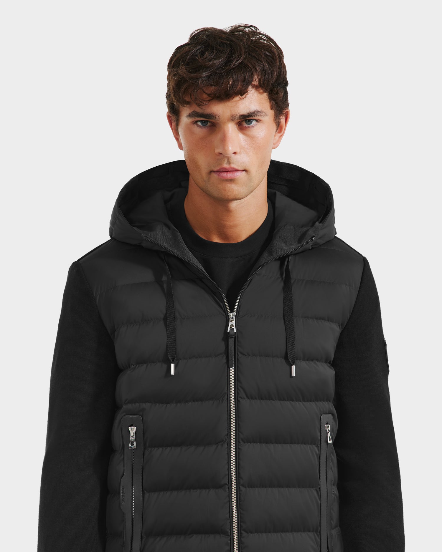 A man in the limited edition Rudsak RIVER HV - H125503 Black hybrid hooded down jacket.