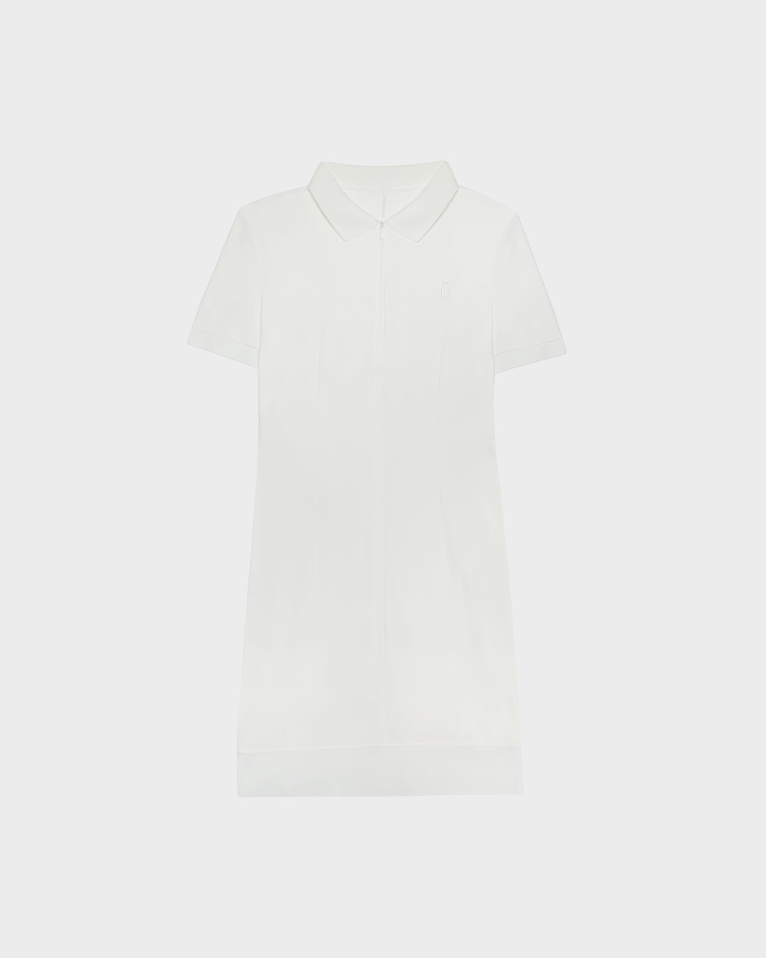 The SUKI - 8524029 Cotton White by Rudsak is a plain white, short-sleeve women's polo dress featuring a collar, front placket, and knee-length hem, capturing sporty elegance against a white background.