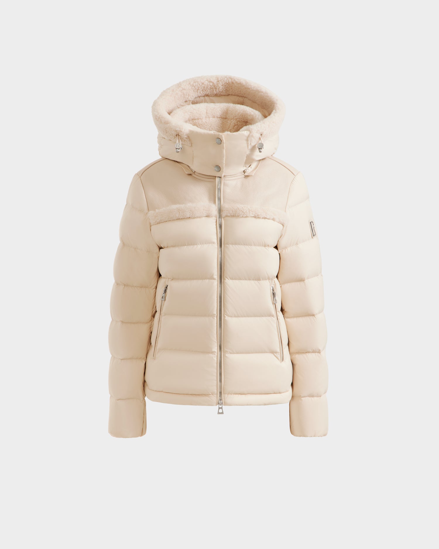 The Rudsak SANDRA - 8125612 Vanilla is a cream-colored women's shearling puffer jacket with a plush hood and zippered front, crafted from recycled nylon and shown on a plain white background.