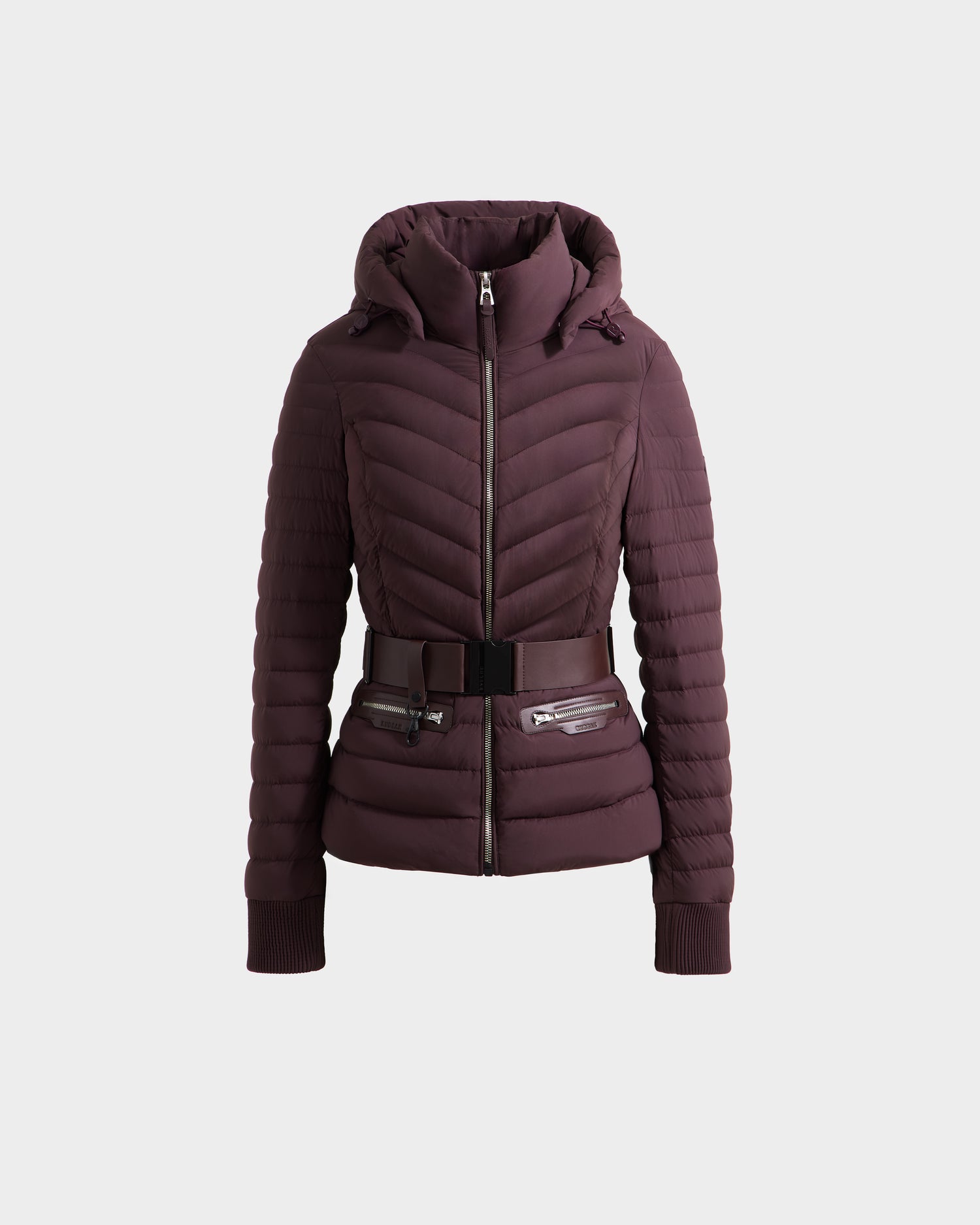 The SCARLETT M - 8125565 Bordeaux by Rudsak is a maroon quilted puffer jacket for women featuring a hood, front zipper, ribbed cuffs, two zippered pockets, and a vegan leather waist belt with metallic buckle—stylish and practical.