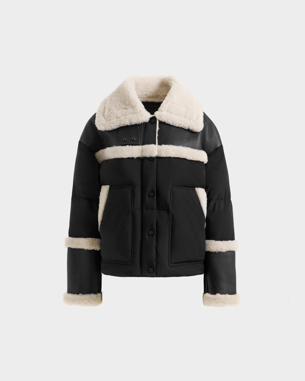 The SHIRLEY - 8125613 Black by Rudsak is a chic women’s down jacket with cream shearling trim on the collar, cuffs, pockets, chest, and sleeves. Shown on a white background, it’s perfect as a cropped winter coat.