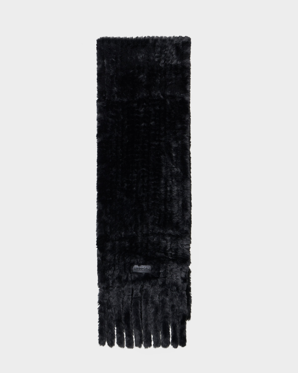 The TAVIA - 8426511 Black scarf by Rudsak features soft, plush black faux fur with a short fringe on one end, shown against a light gray background.