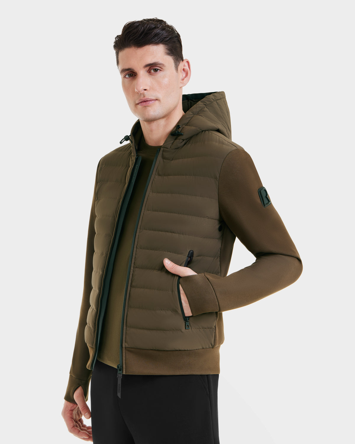 A man in the Rudsak DEE MAT - 6124028 Army green mens lightweight hybrid down jacket—perfect for any urban wardrobe.