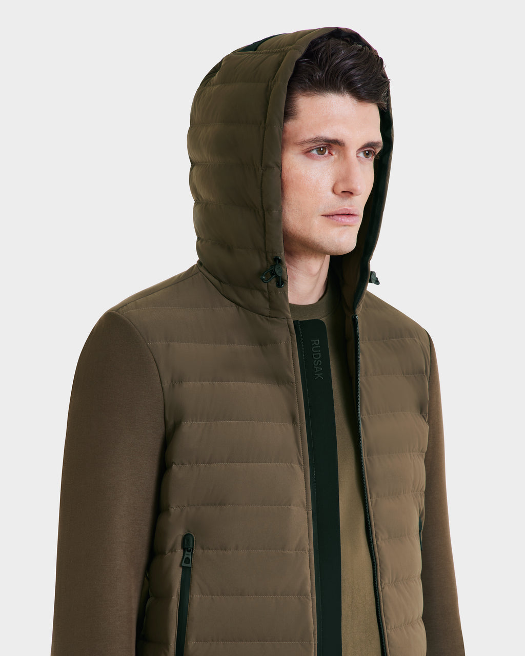 A man in a Rudsak DEE MAT - 6124028 Army mens lightweight hybrid down jacket with zipper pockets and a matching shirt stands facing slightly right against a plain light background.