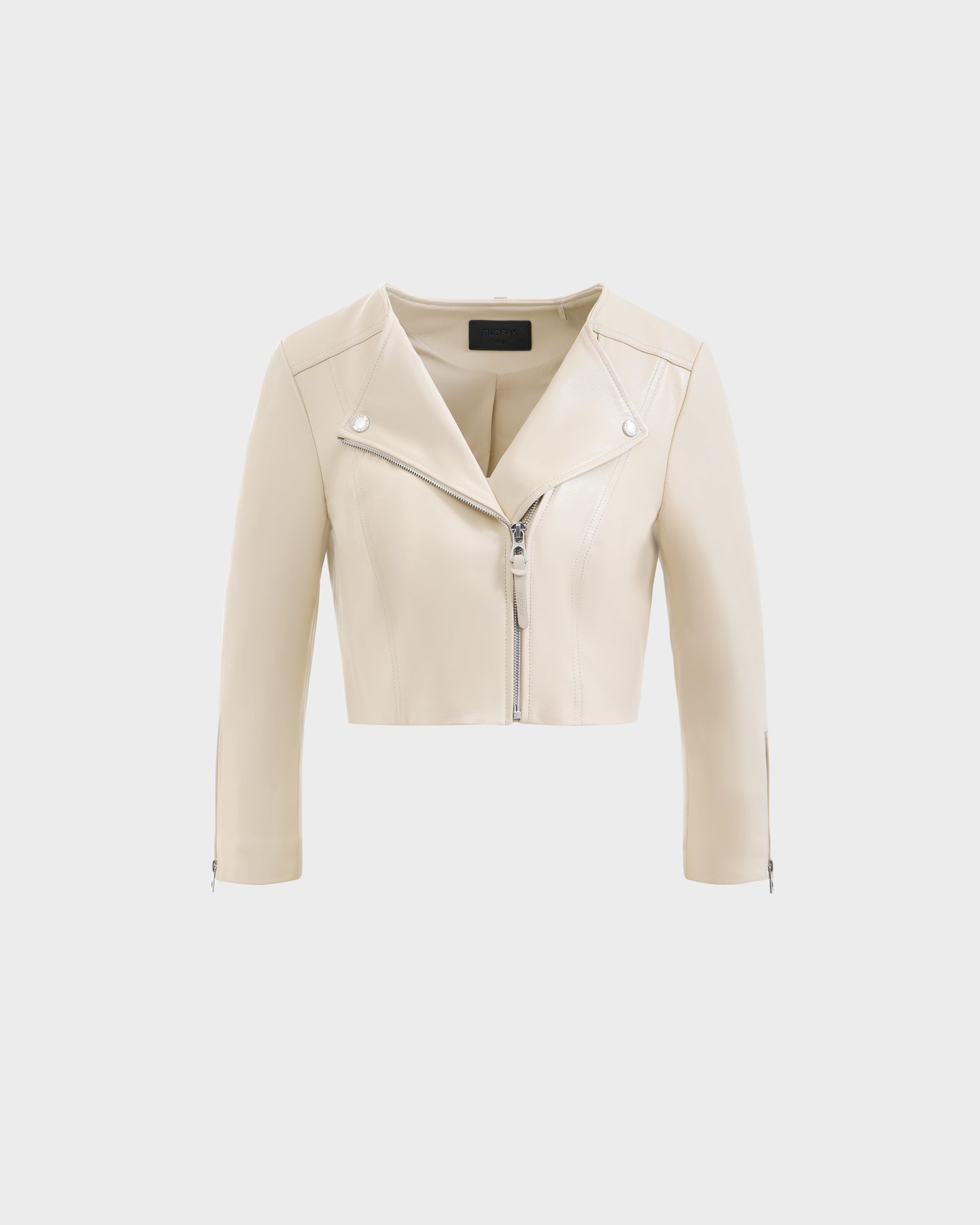 The WINNI - 8124053 Vanilla by Rudsak is a cropped, light beige lamb leather biker jacket with front zipper, silver hardware, long sleeves, and a notched collar, shown on a plain white background—ideal for elevating women’s style.