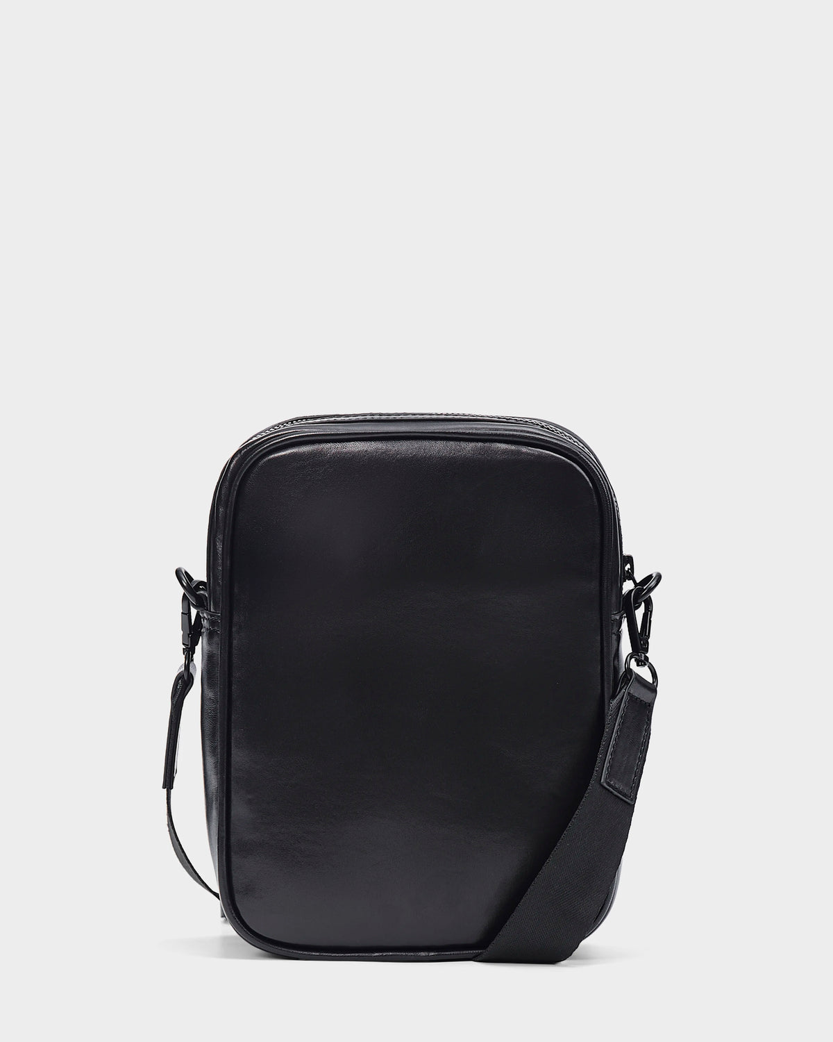 The Rudsak NORMAN L - 9323503 Black is a sleek, unisex leather crossbody bag with a zippered top, smooth finish, and adjustable shoulder strap, shown against a white background. Perfect to complement any style.