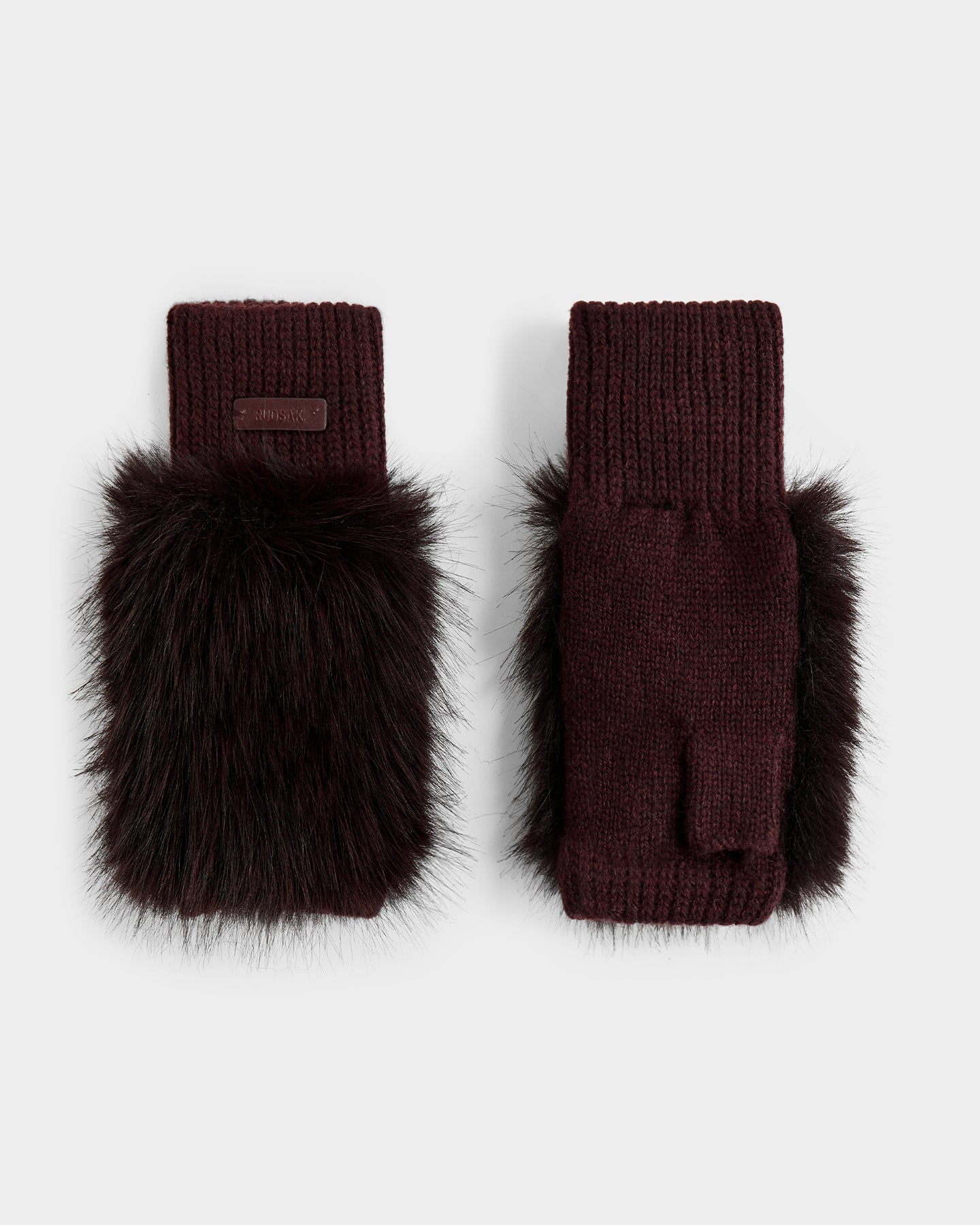 The Rudsak LIA - 8425007 Bordeaux women's fingerless mitten gloves feature a burgundy wool-blend knit and thick dark brown faux fur on the back, shown against a light gray background.