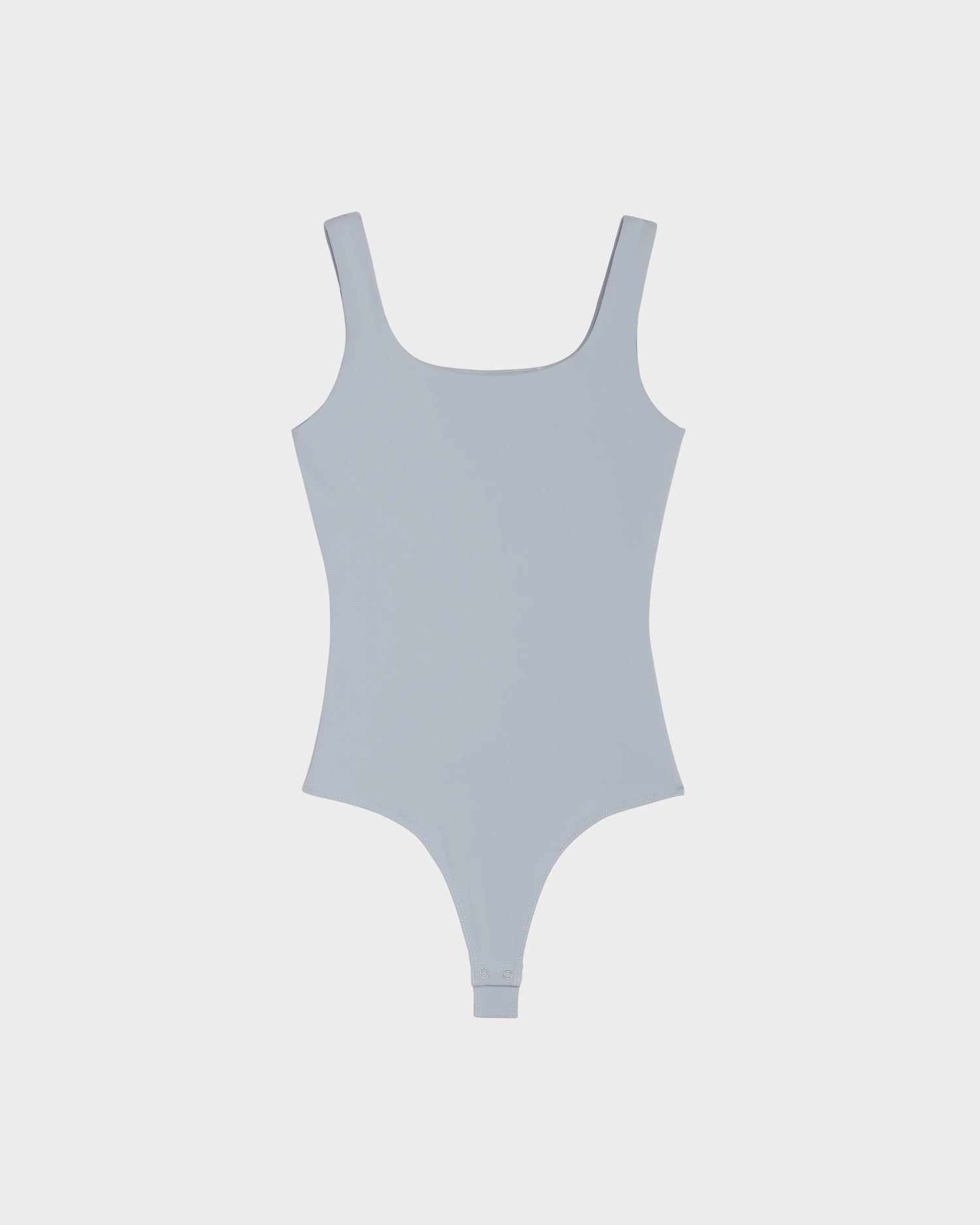 The BRIDGET - 8524033 Sky Blue by Rudsak is a women's bodysuit in sky blue with a tank style, scoop neckline, snap bottom closure, and soft stretch fabric, displayed flat on a plain white background.