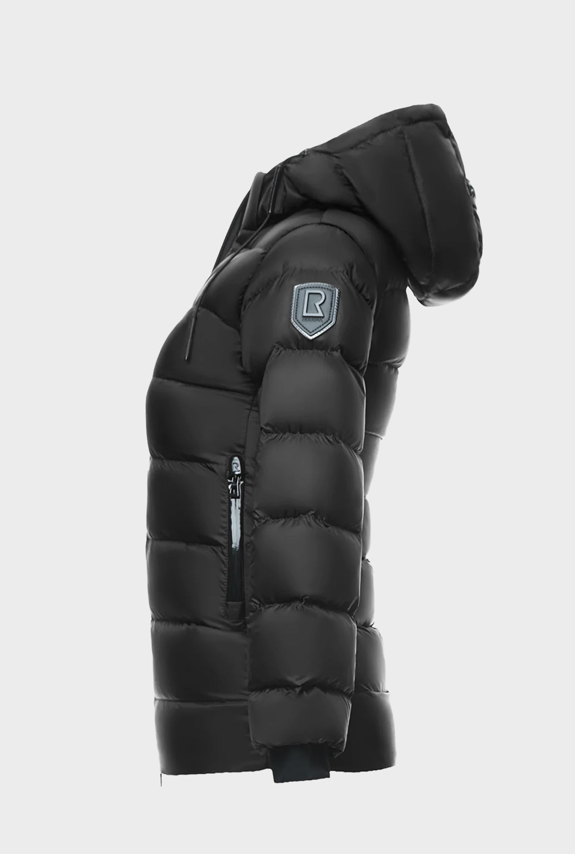 The Rudsak MILIA JR - BLACK K122503 is a kids’ down puffer jacket with a hood, zippered side pocket, and patch logo on the upper sleeve—an ideal winter essential shown in profile against a plain white background.