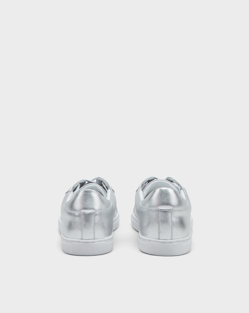 The Rudsak BARNEY - US EN 6220009 SILVER features low-cut, lace-up silver sneakers with white soles, shown from the back against a plain light gray background.
