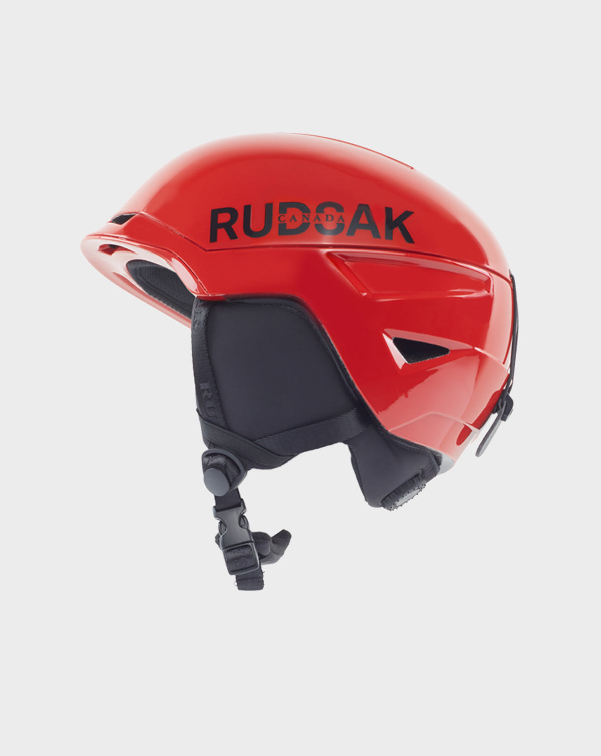 The Rudsak RACE - 9421514 POPPY RED ski helmet features black ear pads and chin strap, bold black branding on the side, and ventilation openings. Part of the Ski Capsule Collection, it has a sleek, aerodynamic design.